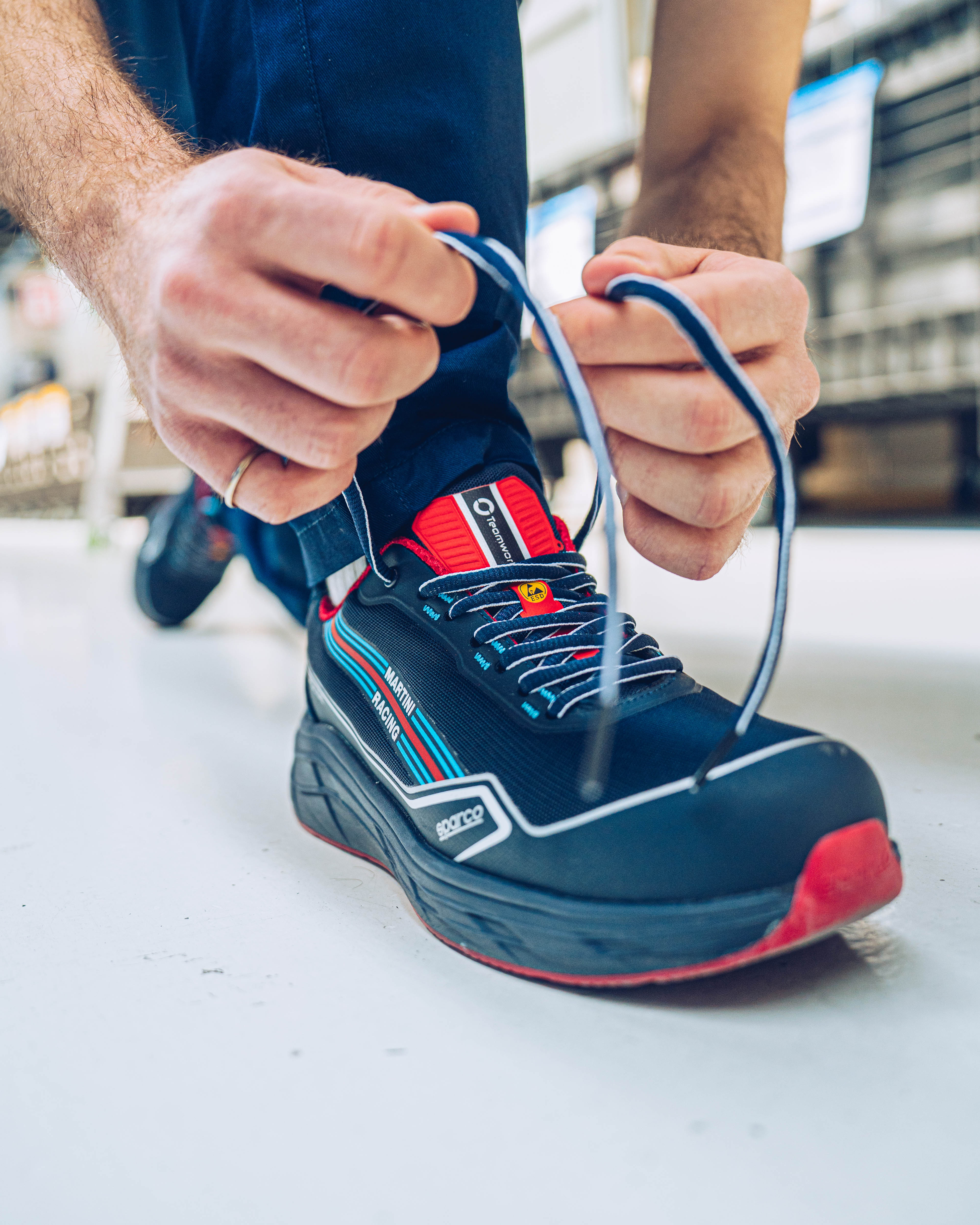 Render vista tre quarti frontale di Kia EV6 in ambiente architettonico moderno e minimalista in stile advertising.