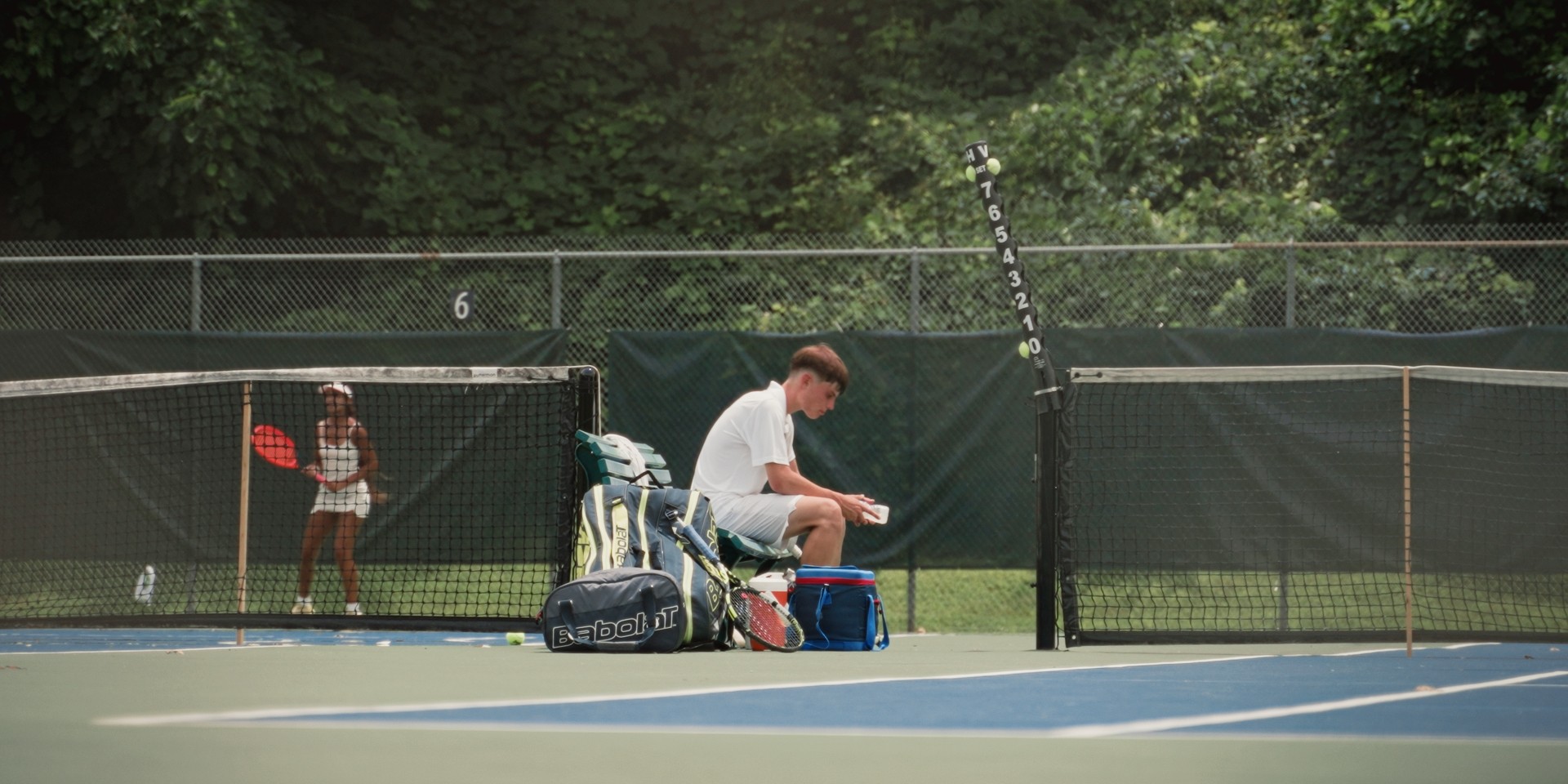 Pause d’un joueur assis au bord du court pendant un match de tennis