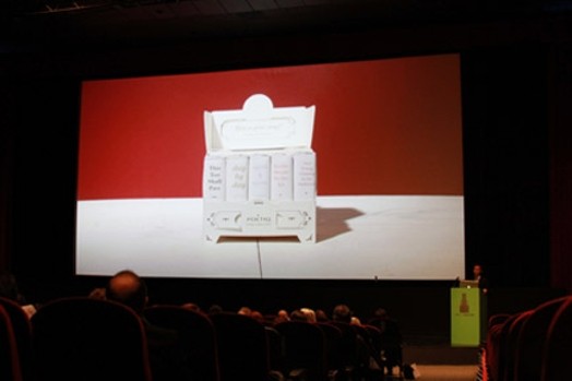 A screen presentation showing a red and white room with a white paper cabinet in the middle.