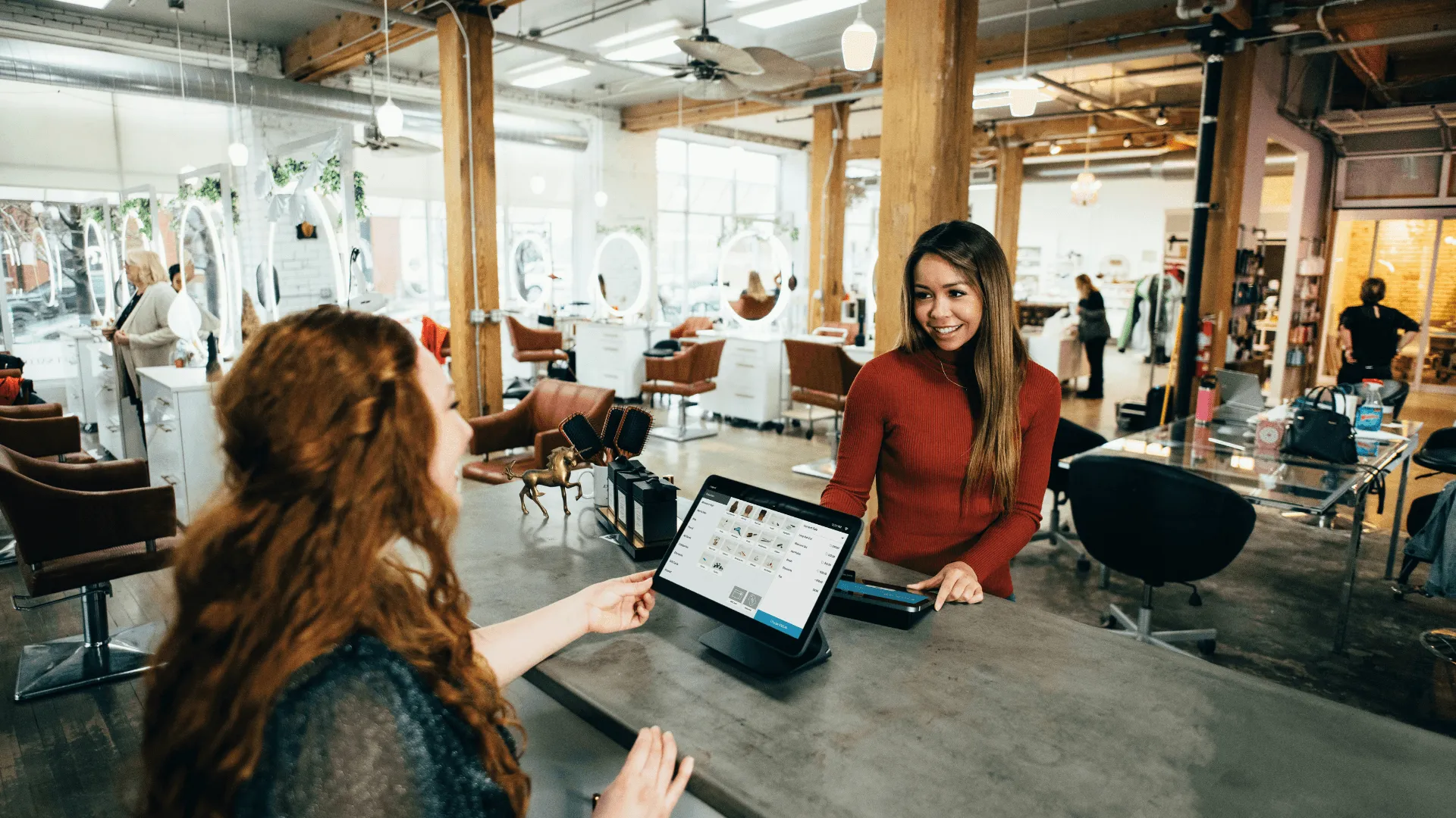 Two women completing a transaction in a clothing store
