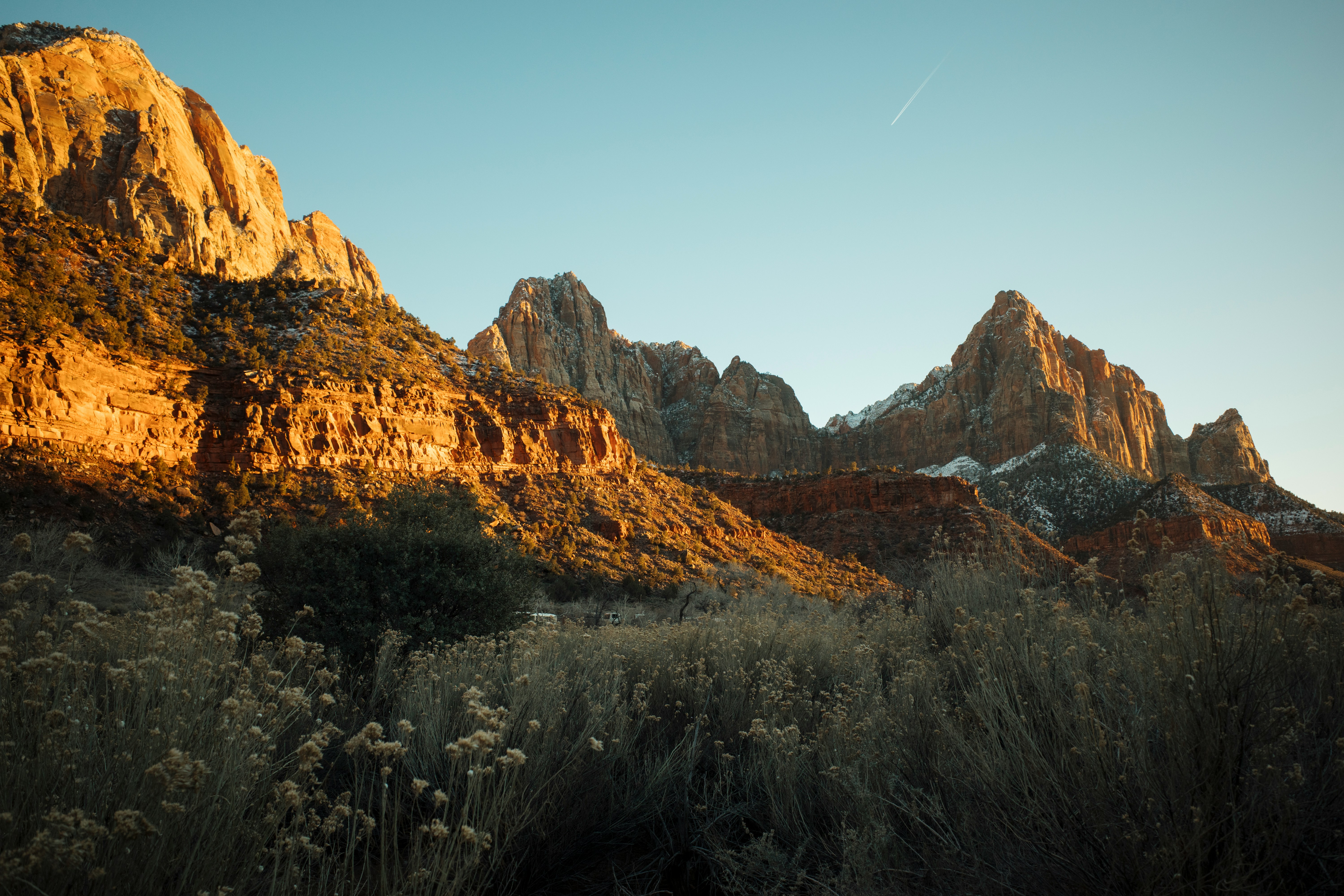 Golden sunlight illuminates rugged mountain peaks at dawn.