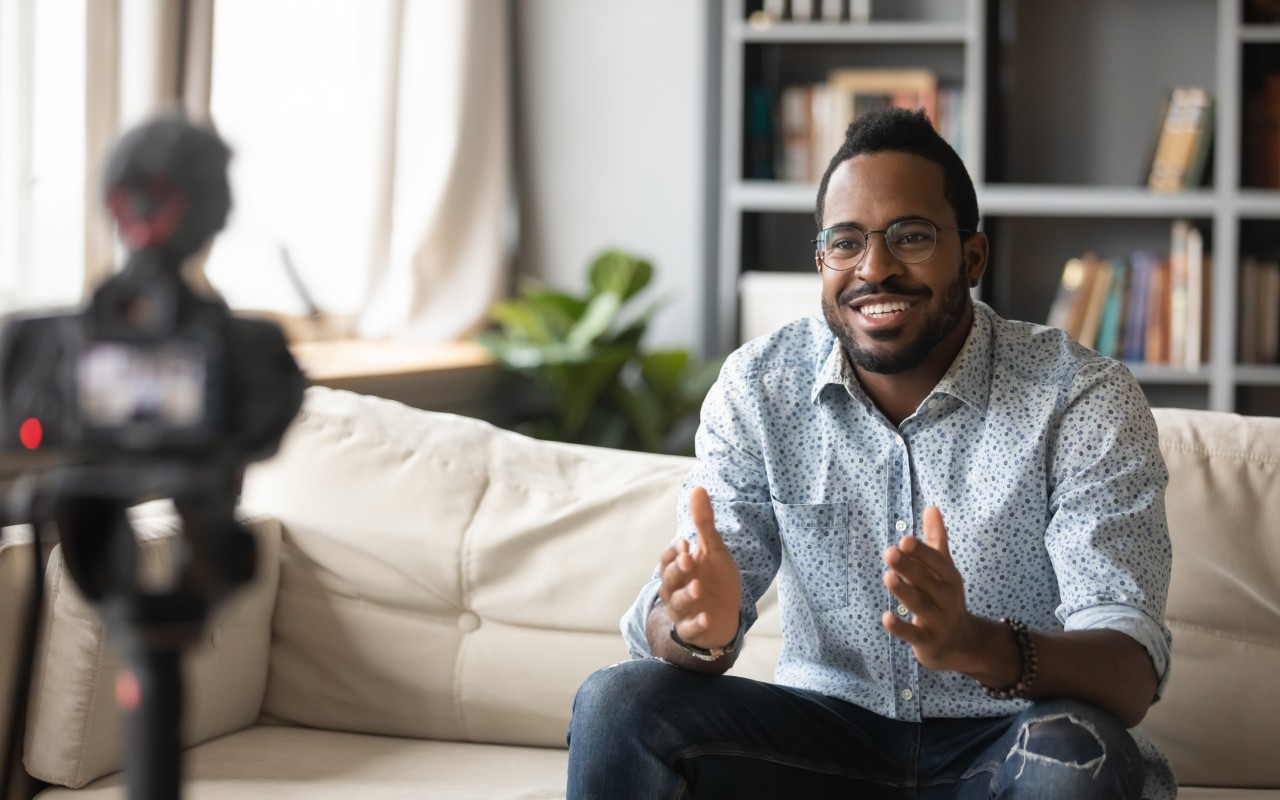 A man recording a corporate communication video on a camera.