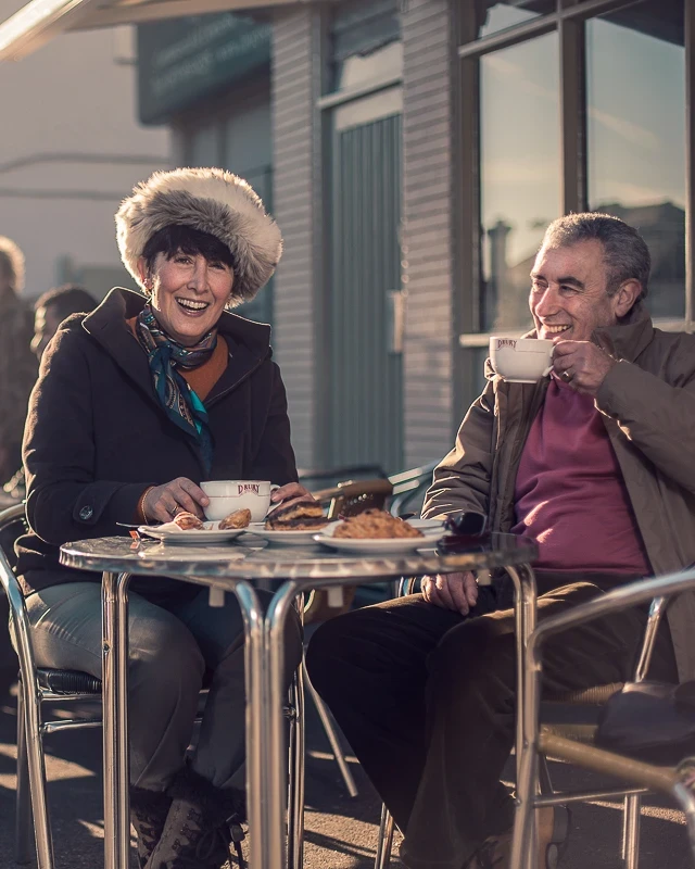 Couple outside cafe drinking coffee