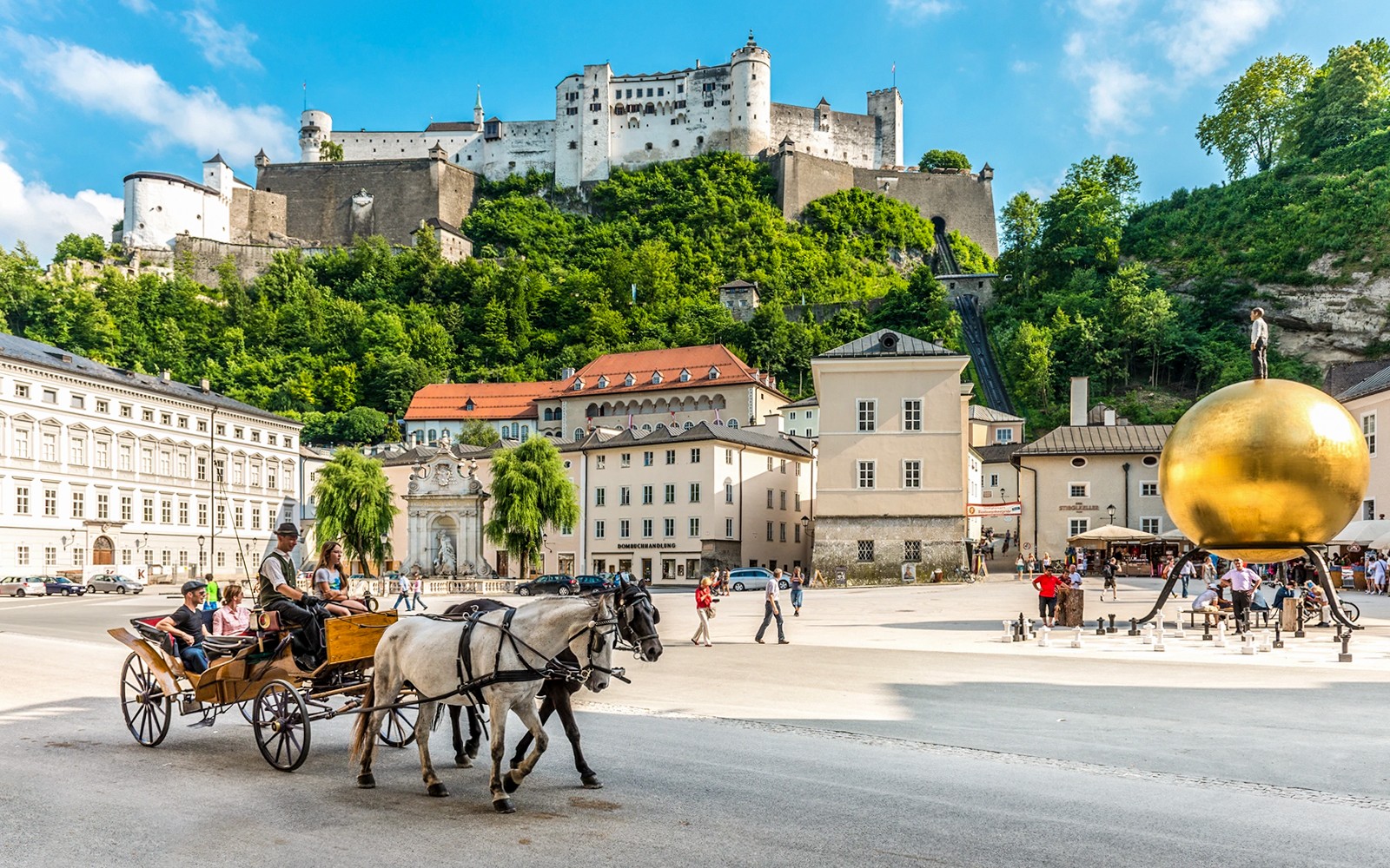 Hestevogn på Salzburgs Kapitelplatz med Hohensalzburg-fæstningen i baggrunden.