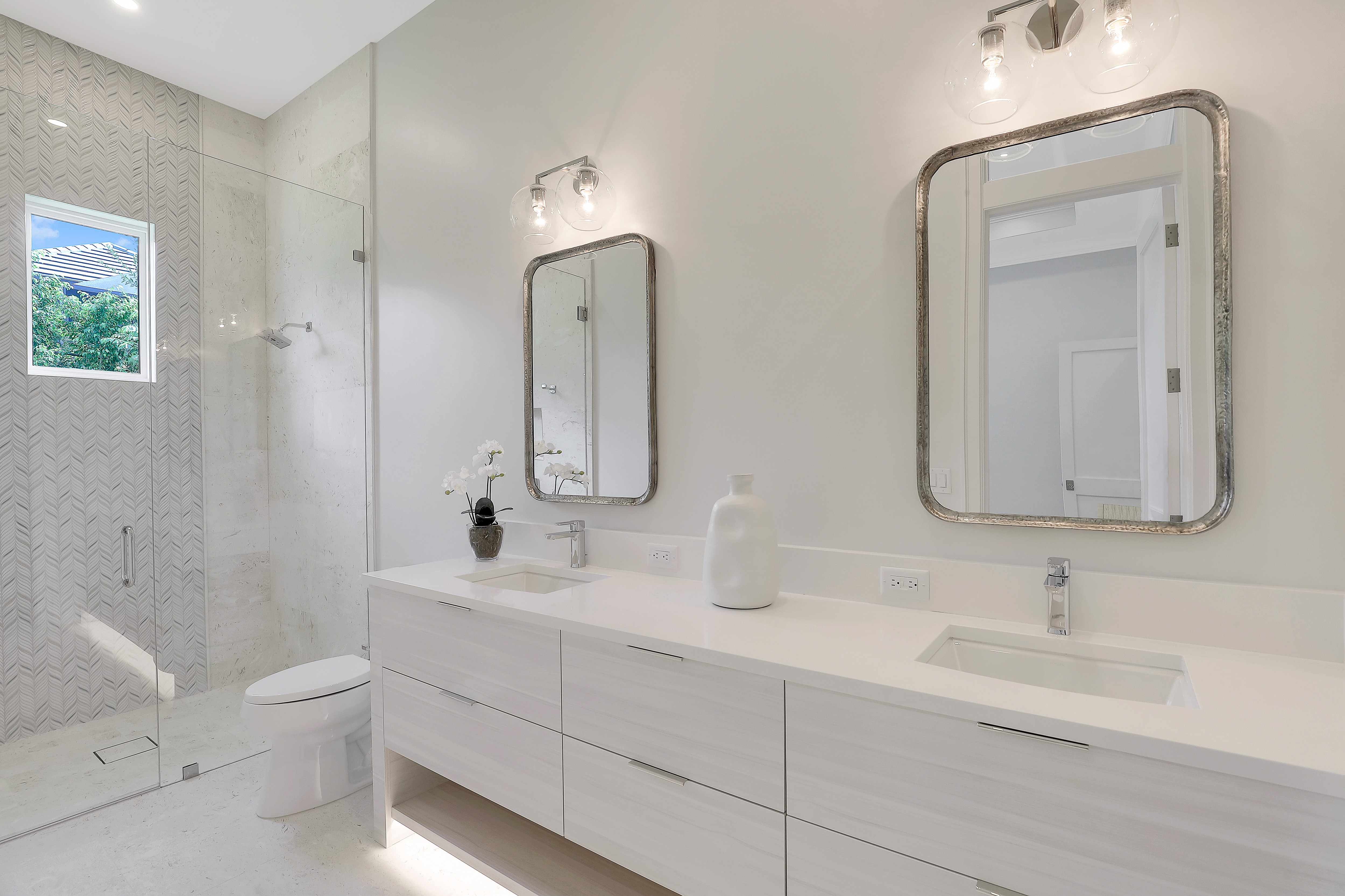 a modern white bathroom with twin sinks and mirros