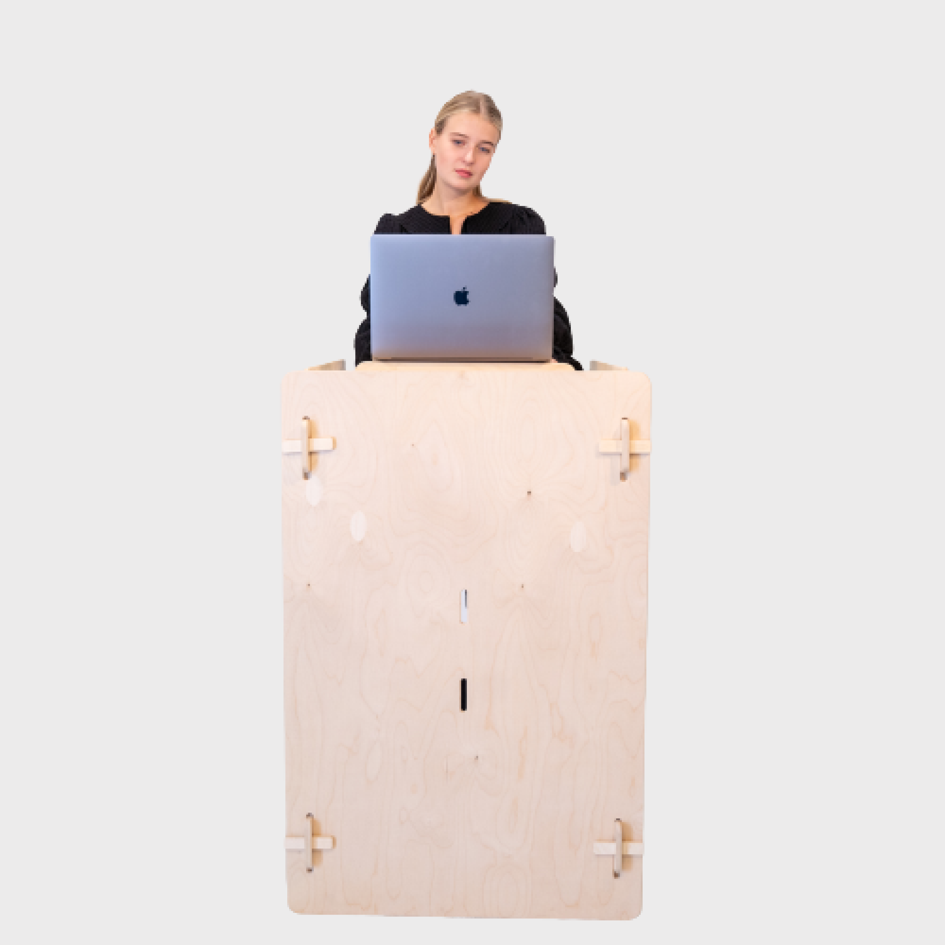 A woman using a silver Macbook Pro on the 100 Tree Furniture quick assembly desk with the desk in standing position.