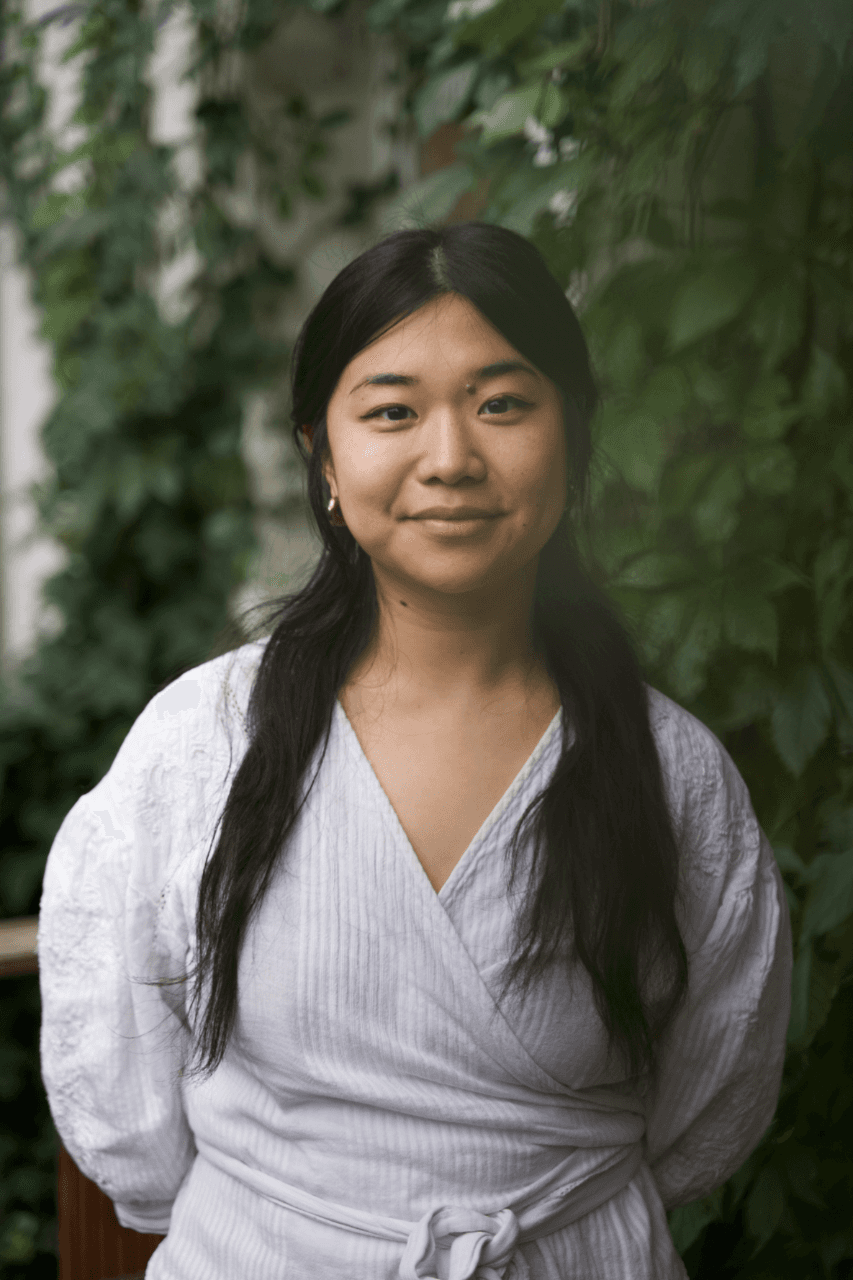 Künstlerisches Profilfoto von Lucia Deyi mit einem roten Hintergrund