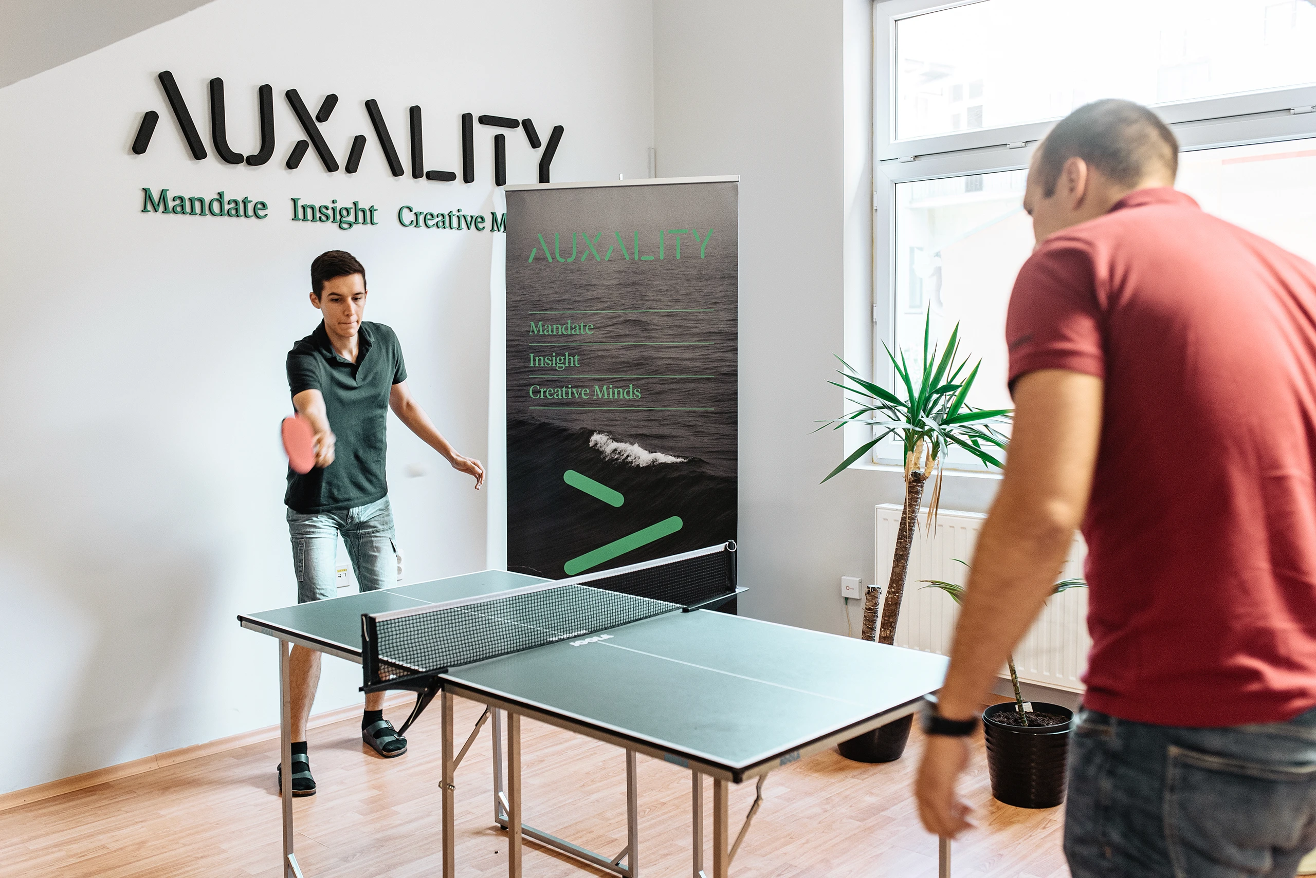 Colleagues playing table tennis during a break in a modern office.