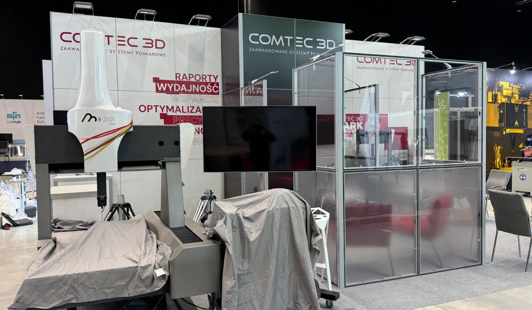 Aranżacja boksu targowego – widok na strefę spotkań i ekspozycję multimedialną na stoisku.