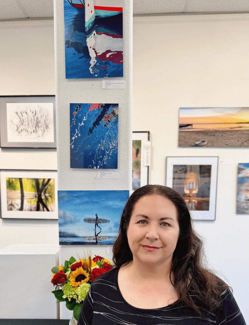Me in front of my photo prints at a Coastal Arts League Juried Photo show with the theme "Reflections."