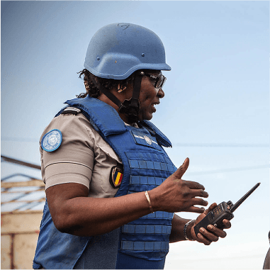 UN employee with helmet, bullet proof vest, and a radio in their hand