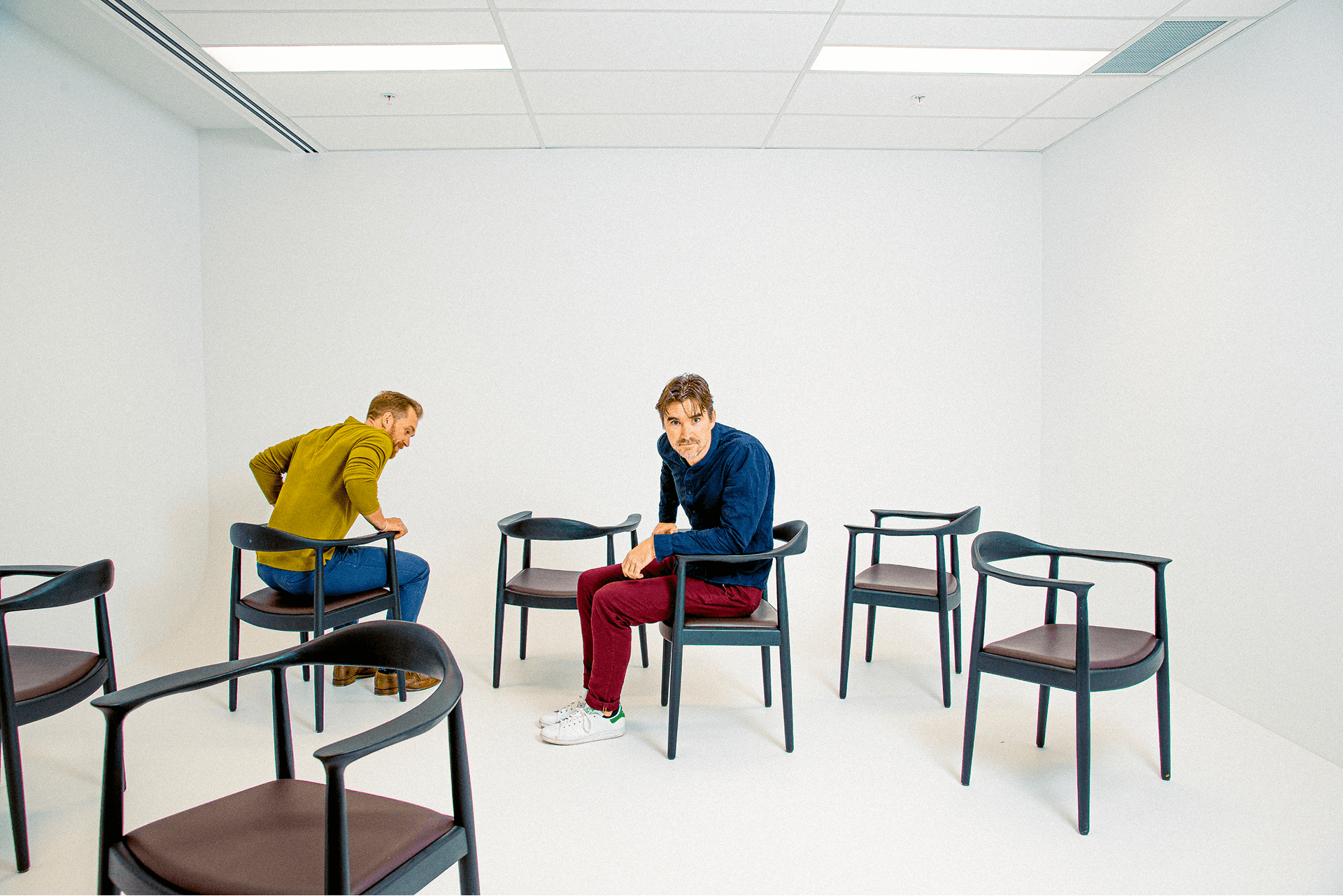 Kieran Antill and Ross Hastings in room with empty chairs
