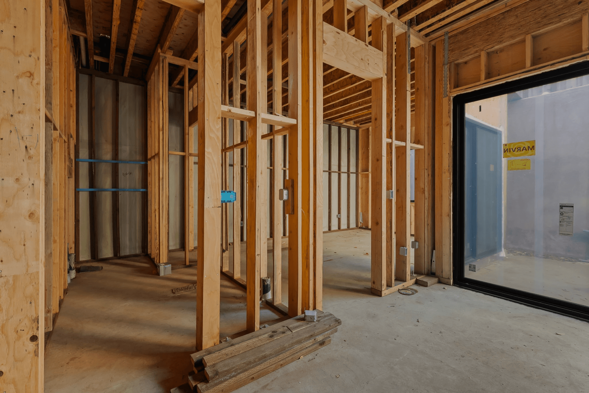 Interior bedroom with modern furnishings and large windows, representing Six Sigma Construction’s design-forward custom home work.