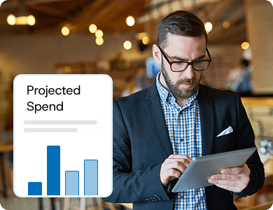 Business professional reviewing financial charts on a laptop with a “Projected Spend” graph overlay, representing confident spend forecasting.