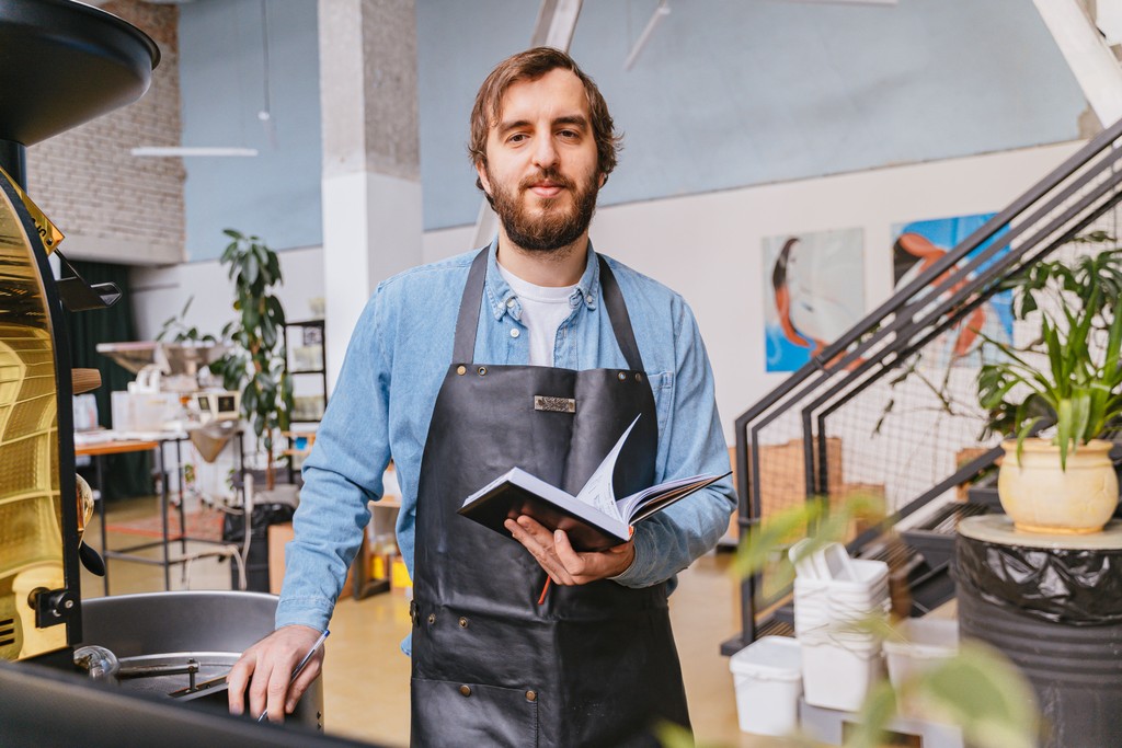 Man in a coffee shop wearing an apron