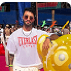 Gabriel Feitosa smiling at an outdoor event surrounded by colorful decorations to convey confidence, creativity, and vibrant personality