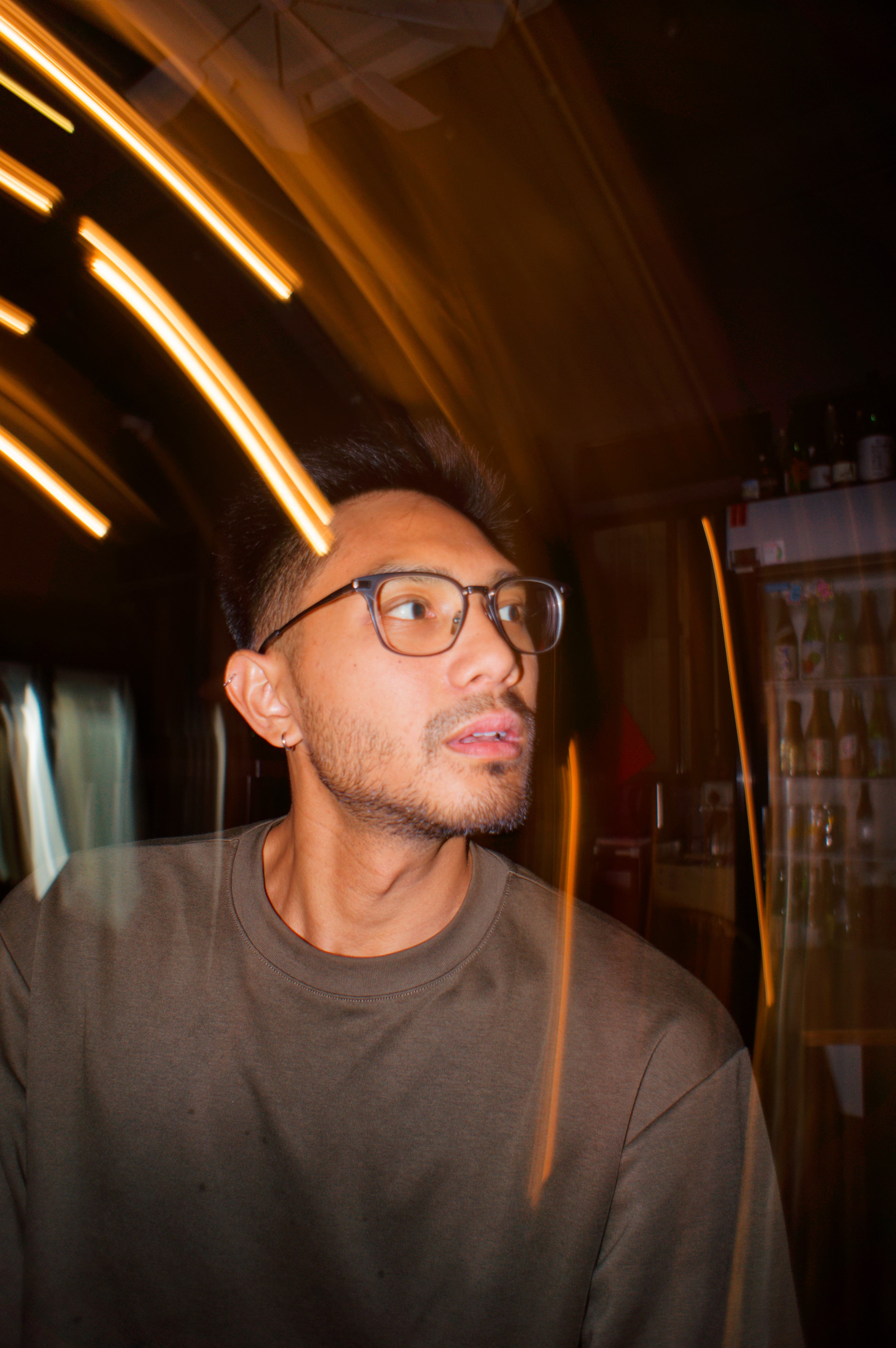 a model posing with lights flaring in front of him from slow shutter