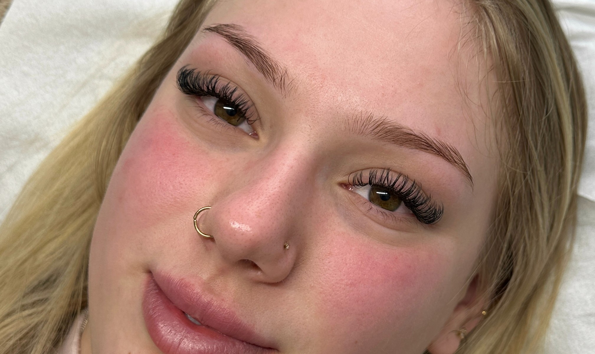 Client with brown eyes modelling the Signature set eyelash extensions