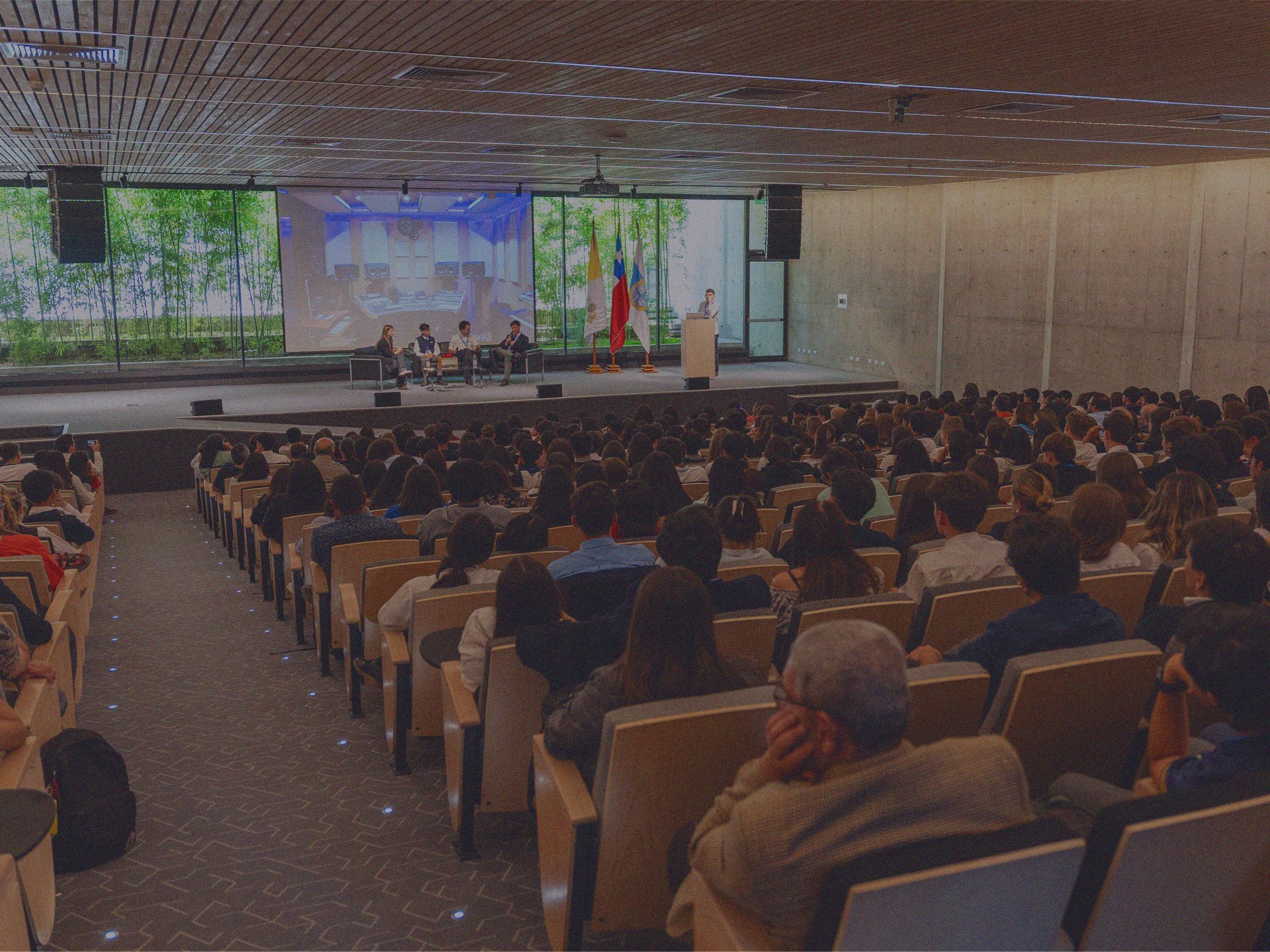 Jóvenes participan de un panel en un escenario frente a cientos de escolares en el Encuentro de Líderes Jóvenes de IdeaPaís.
