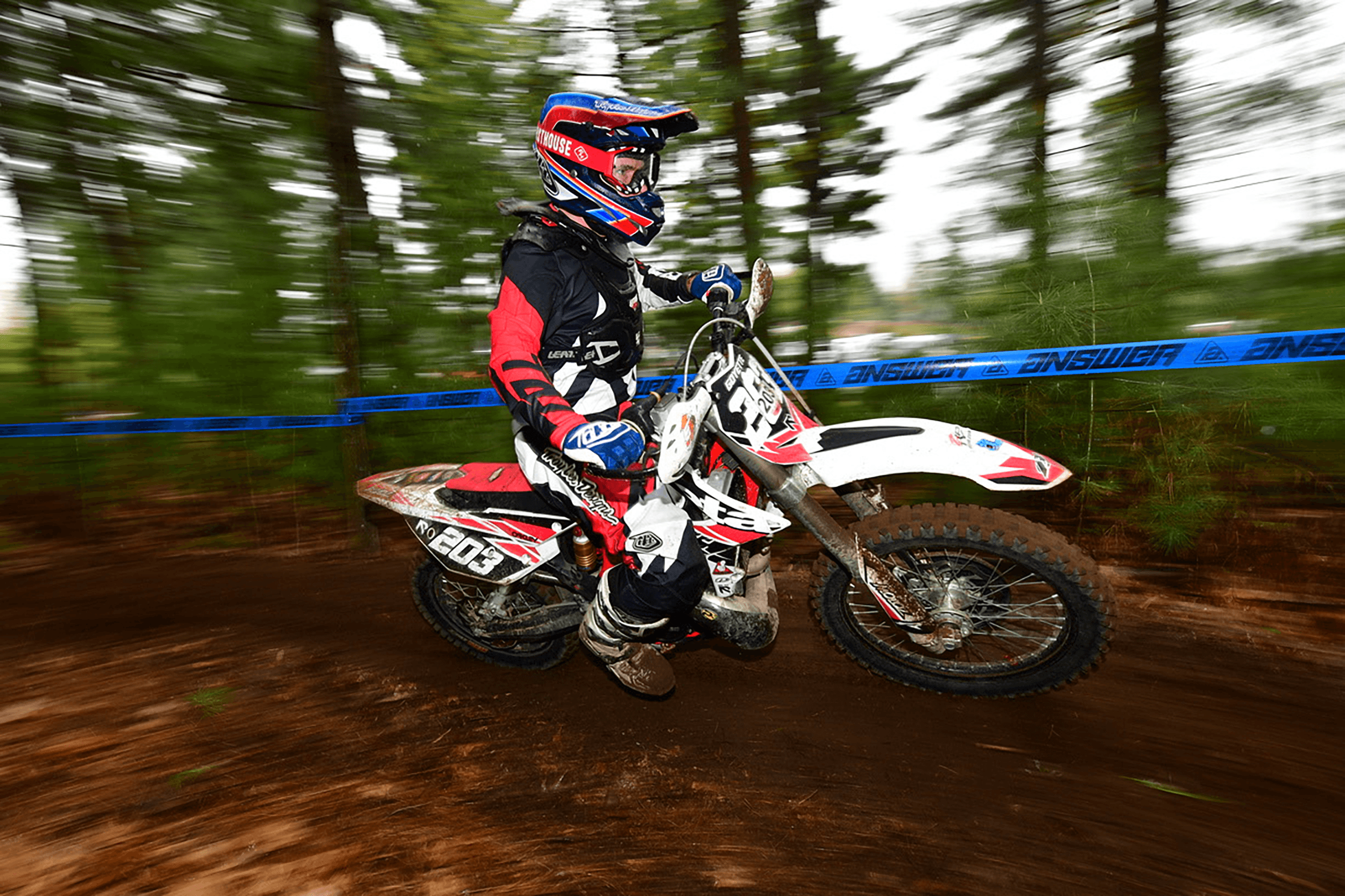 Black and white image of people working at a table with laptops, showing hands gesturing during discussion of digital content displayed on screens, with fabrica® logo in the corner.