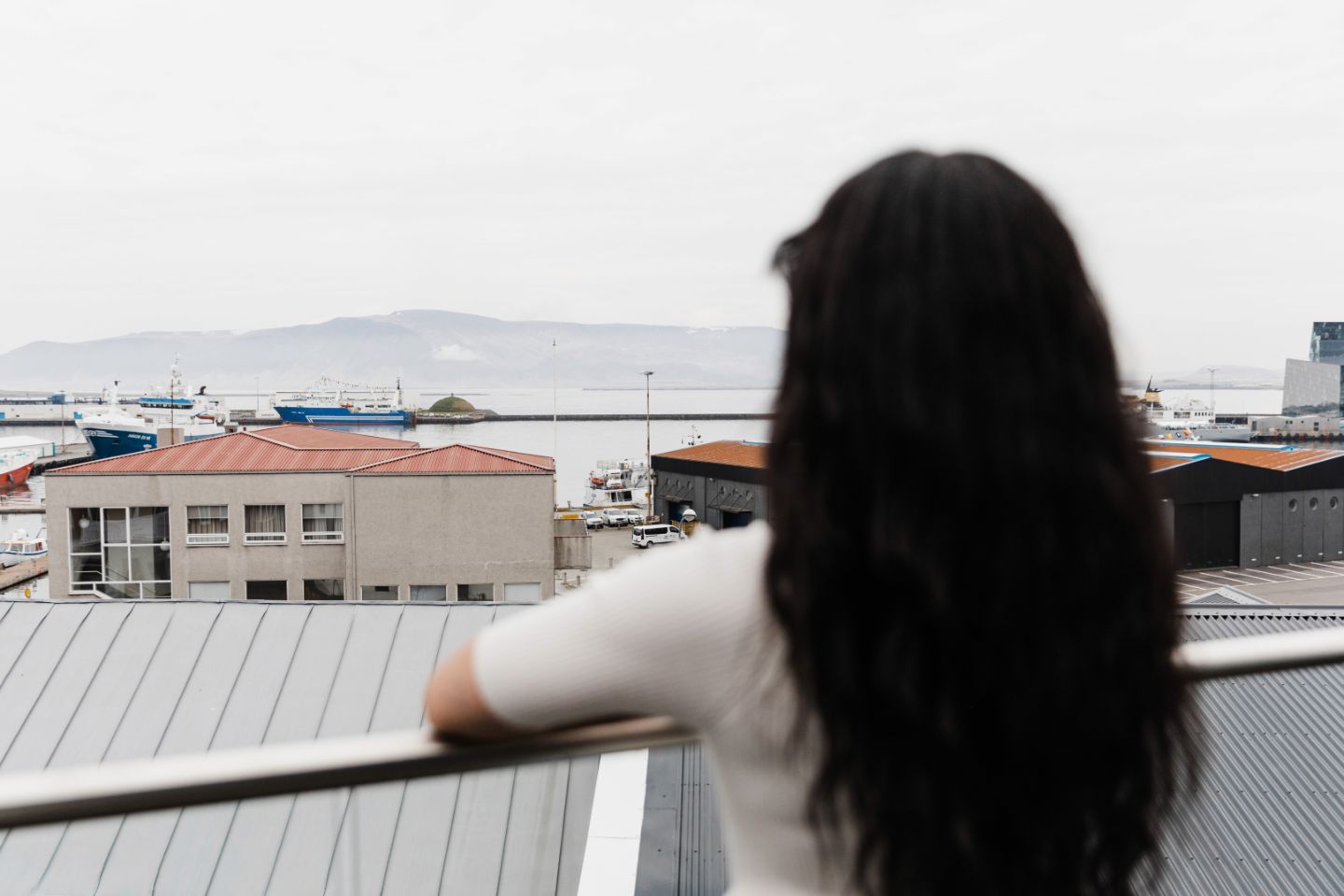 Guest enjoying the view of Reykjavík Old Harbor from Exeter Hotel overlooking Faxaflói Bay.