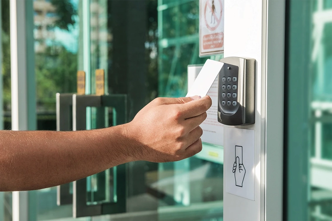 Person scanning a key card at a business entrance door, representing access control and security measures relevant to negligent security cases