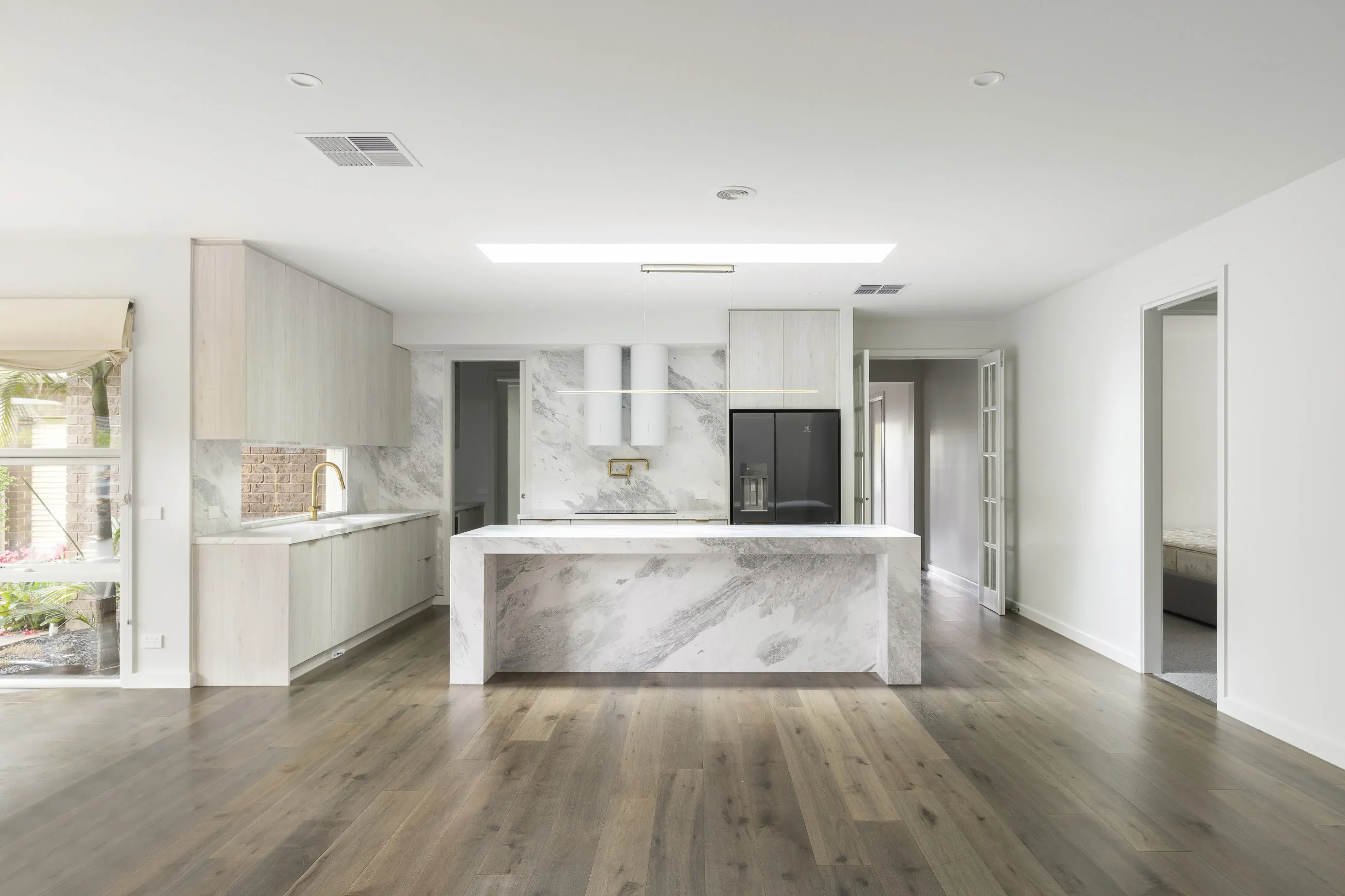 Bundoora Residence kitchen with a marble waterfall island, whitewashed oak joinery and brushed brass fittings