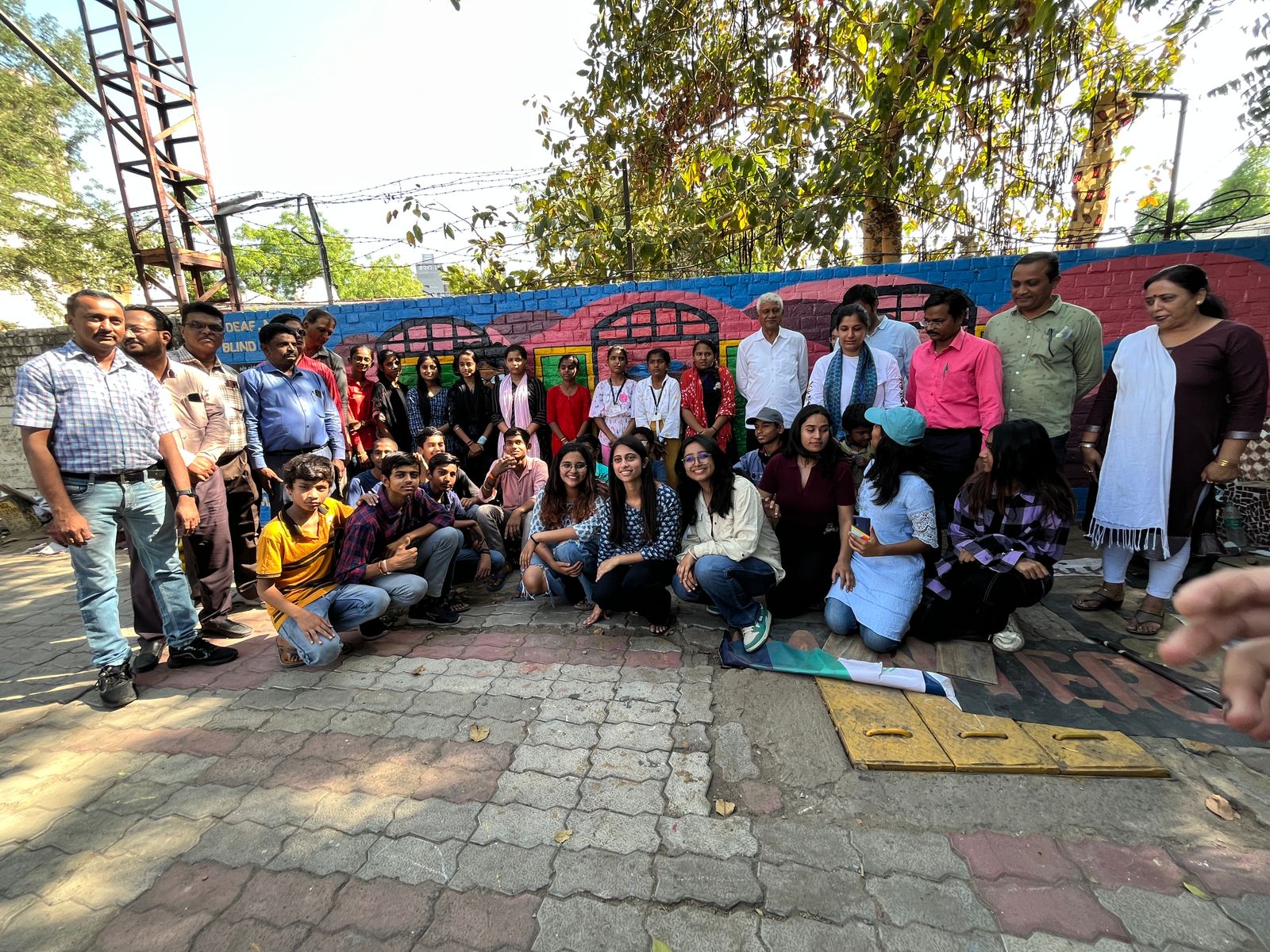 Modern home office setup with a monitor, ergonomic chair, keyboard, and indoor plants near a window with blinds.