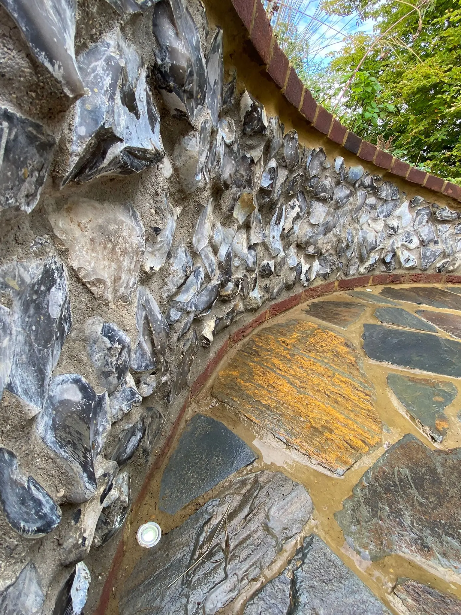 Close-up of a textured stone wall with moss, blending natural elements and earthy colors.