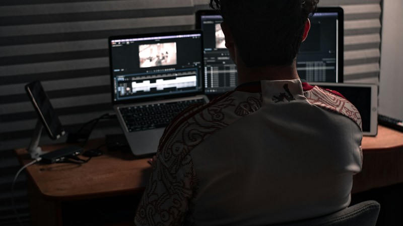 Person working at a computer in a dark creative workspace