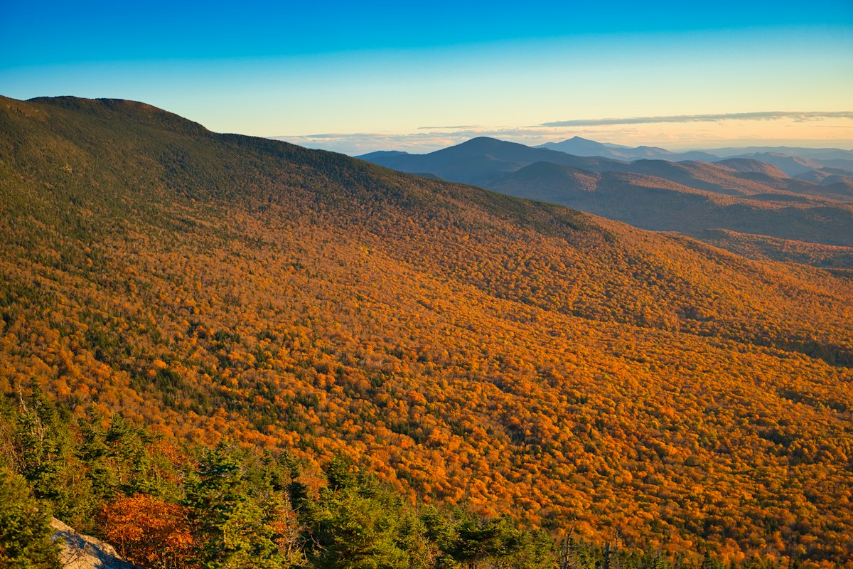 Golden hillsides below Mount Mansfield in Stowe during Vermont fall foliage season