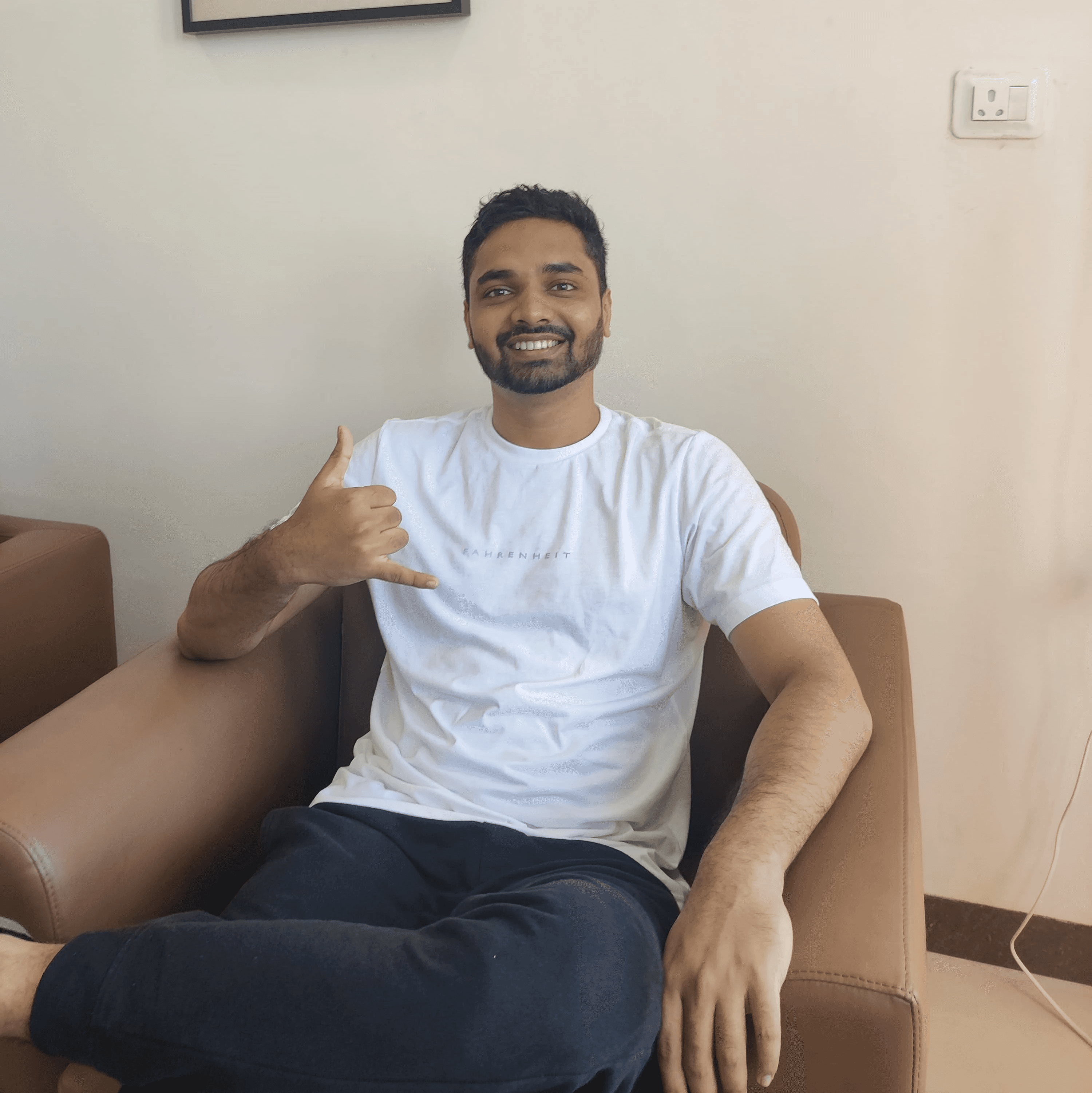 man sitting near gray steel roller shutters during daytime