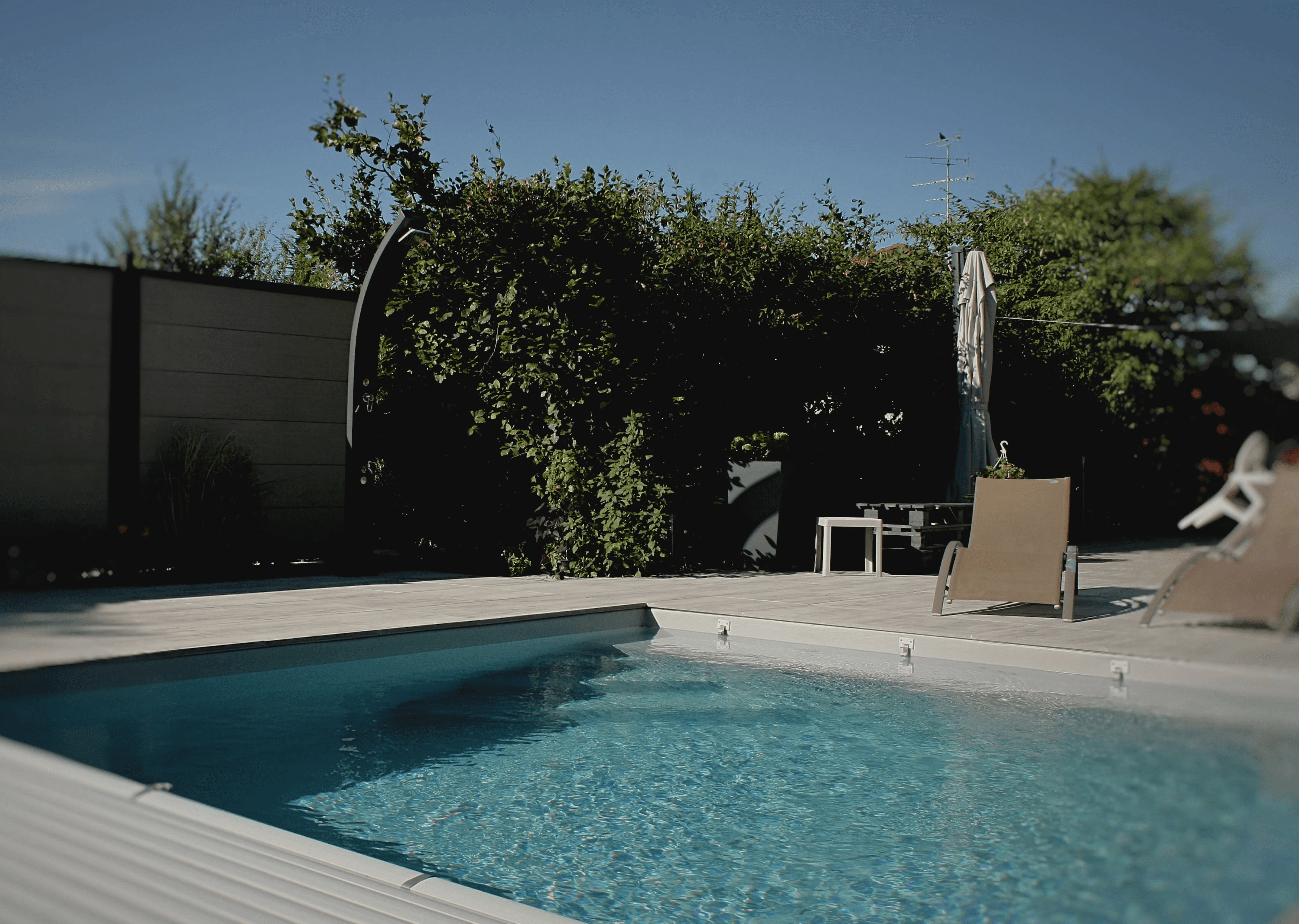 Piscine béton sur-mesure avec volet roulant immergé et espace détente, réalisée par Acqua Terra dans le Haut-Rhin