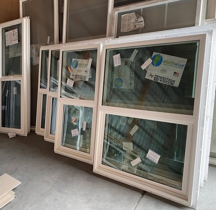 Western Window Systems vinyl windows in stock, featuring energy-efficient double-pane glass and factory labeling.