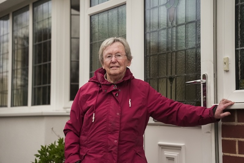 Woman standing in the entrance of her home.