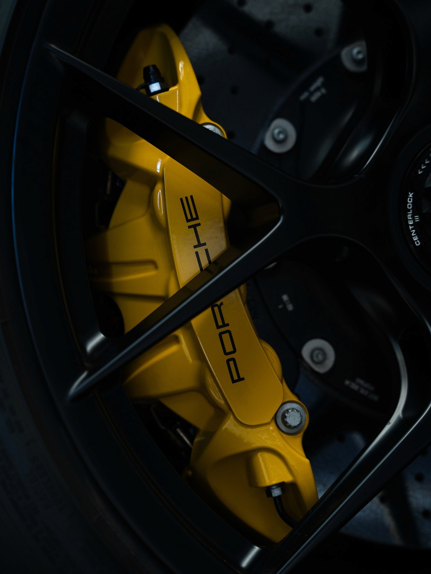 Three people sitting on a couch in a room looking at mobile devices