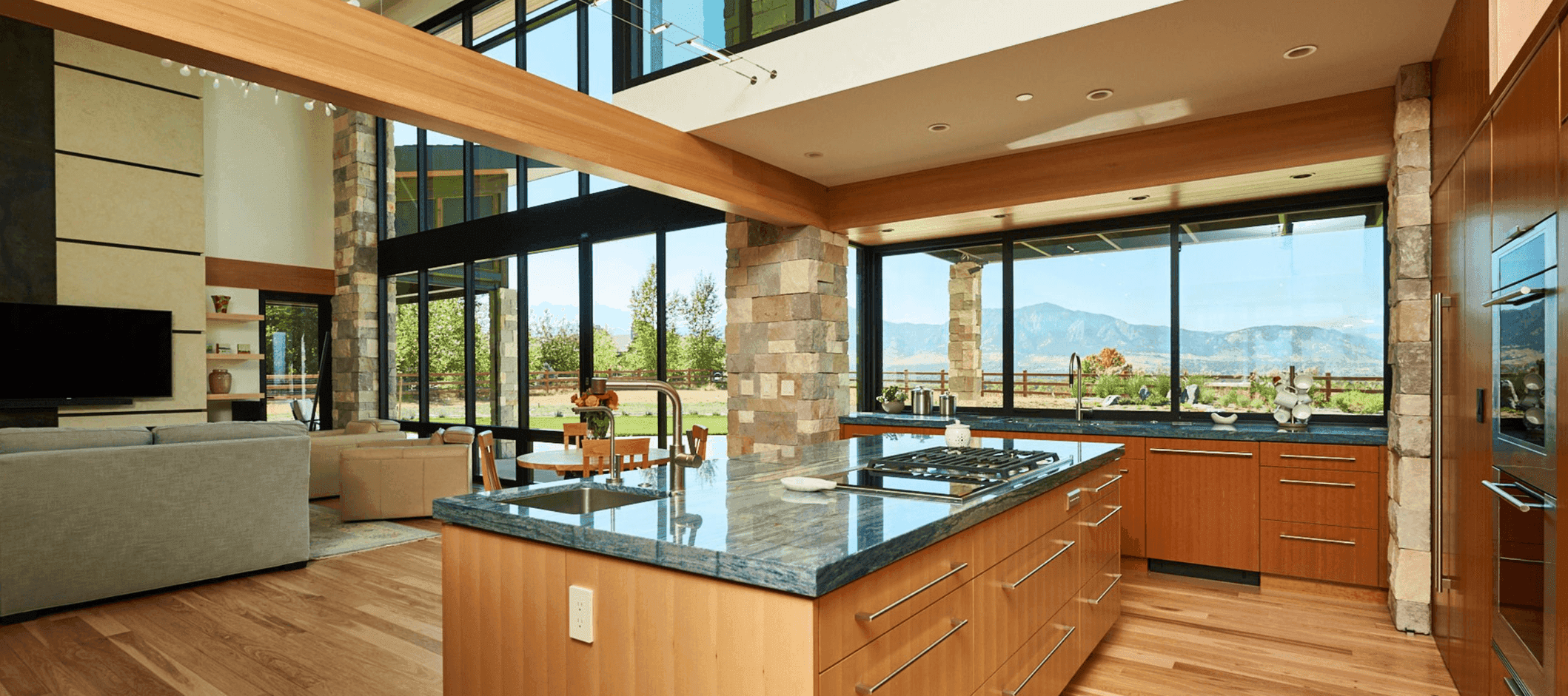 Kitchen with vertical grain fir cabinets, a stone column and a window wall looking out to the Front Range.
