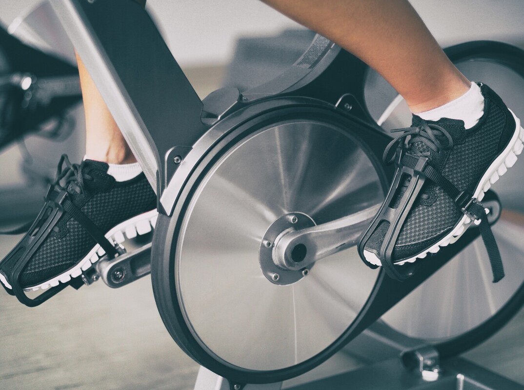 closeup of a person using a spin bike to lose weight at the gym