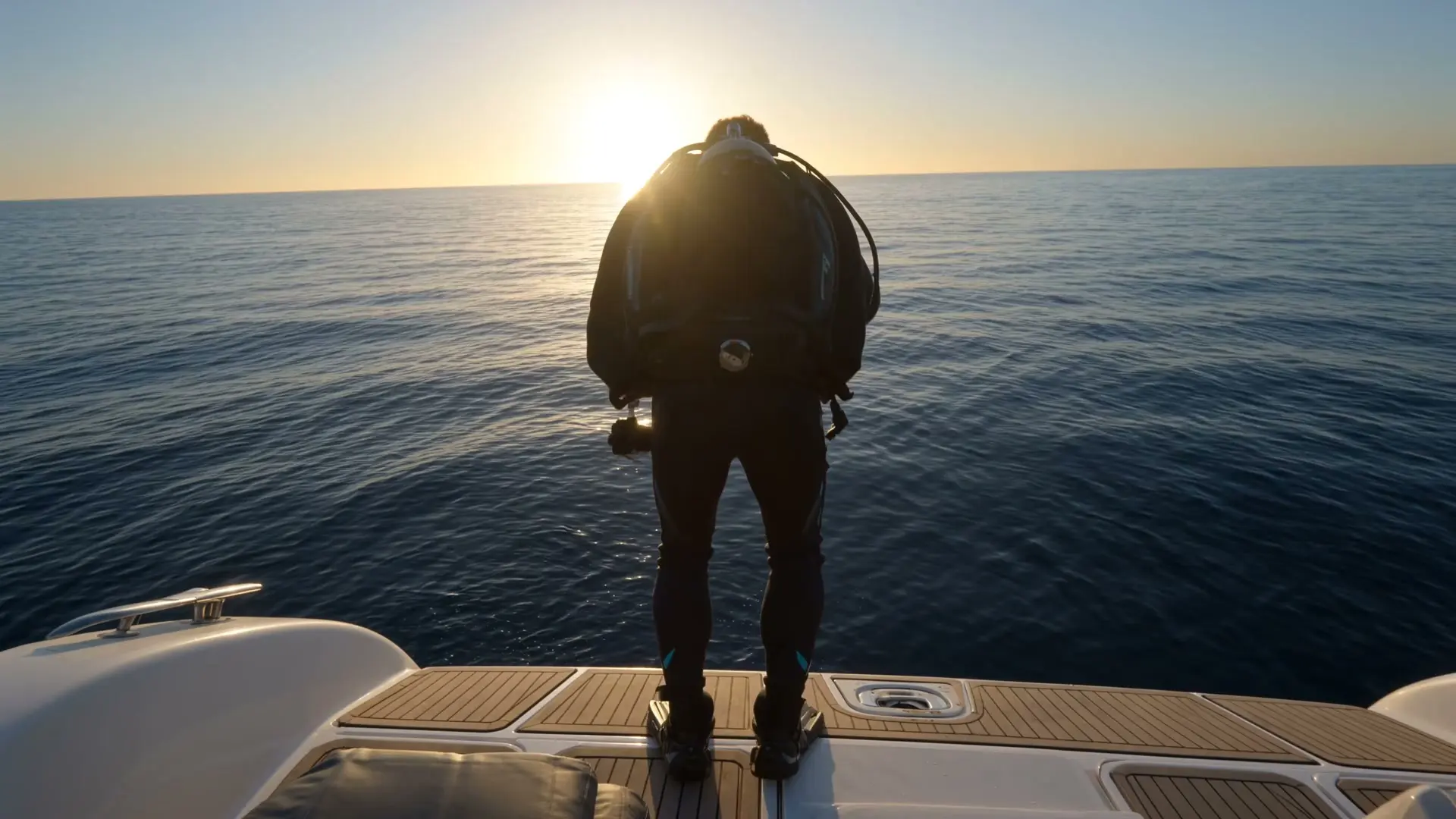 Diver on the stern of the dive boat at sunrise