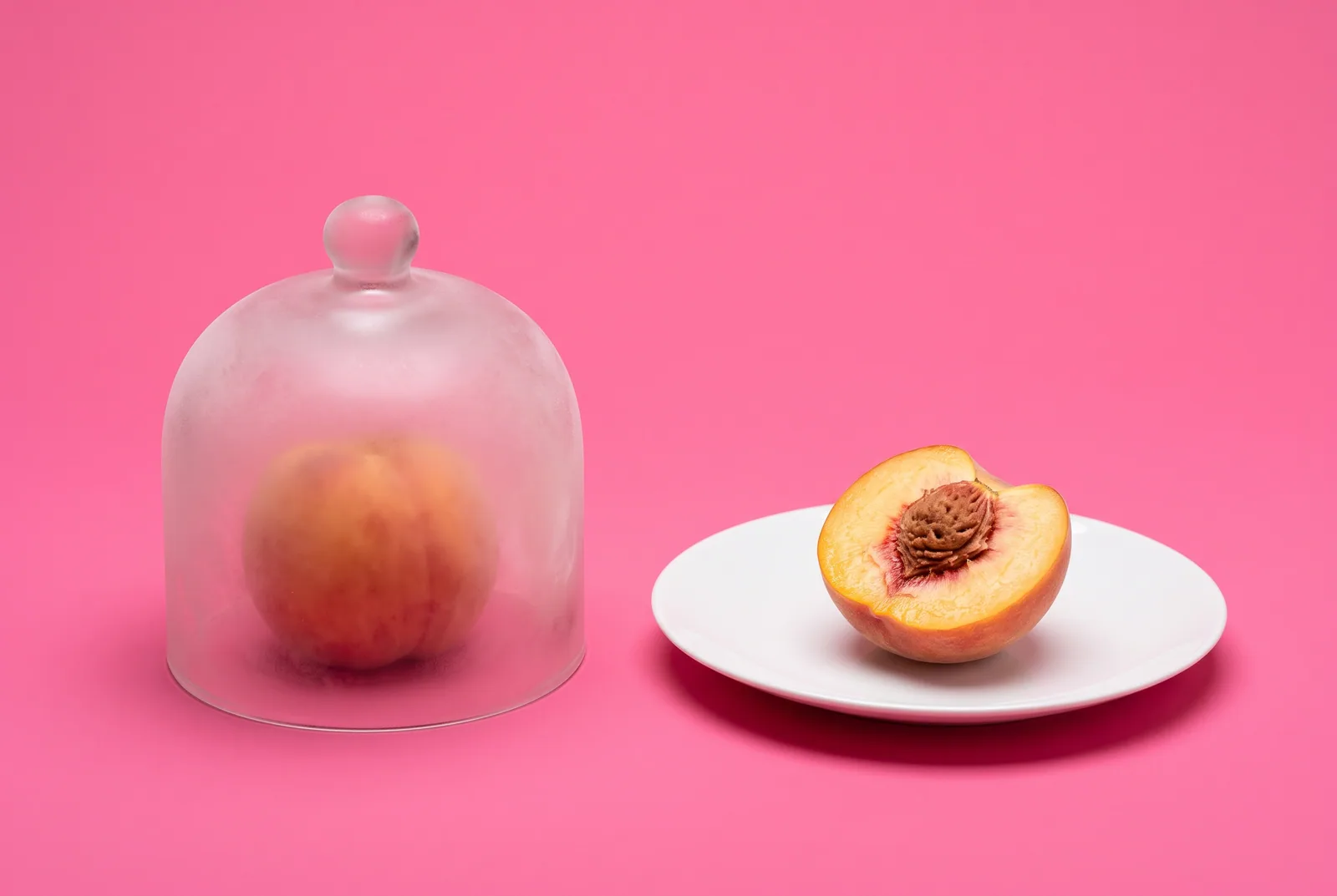 iPhone vs Android accountability software concept: a peach under a frosted glass cloche next to a halved peach on an open white plate