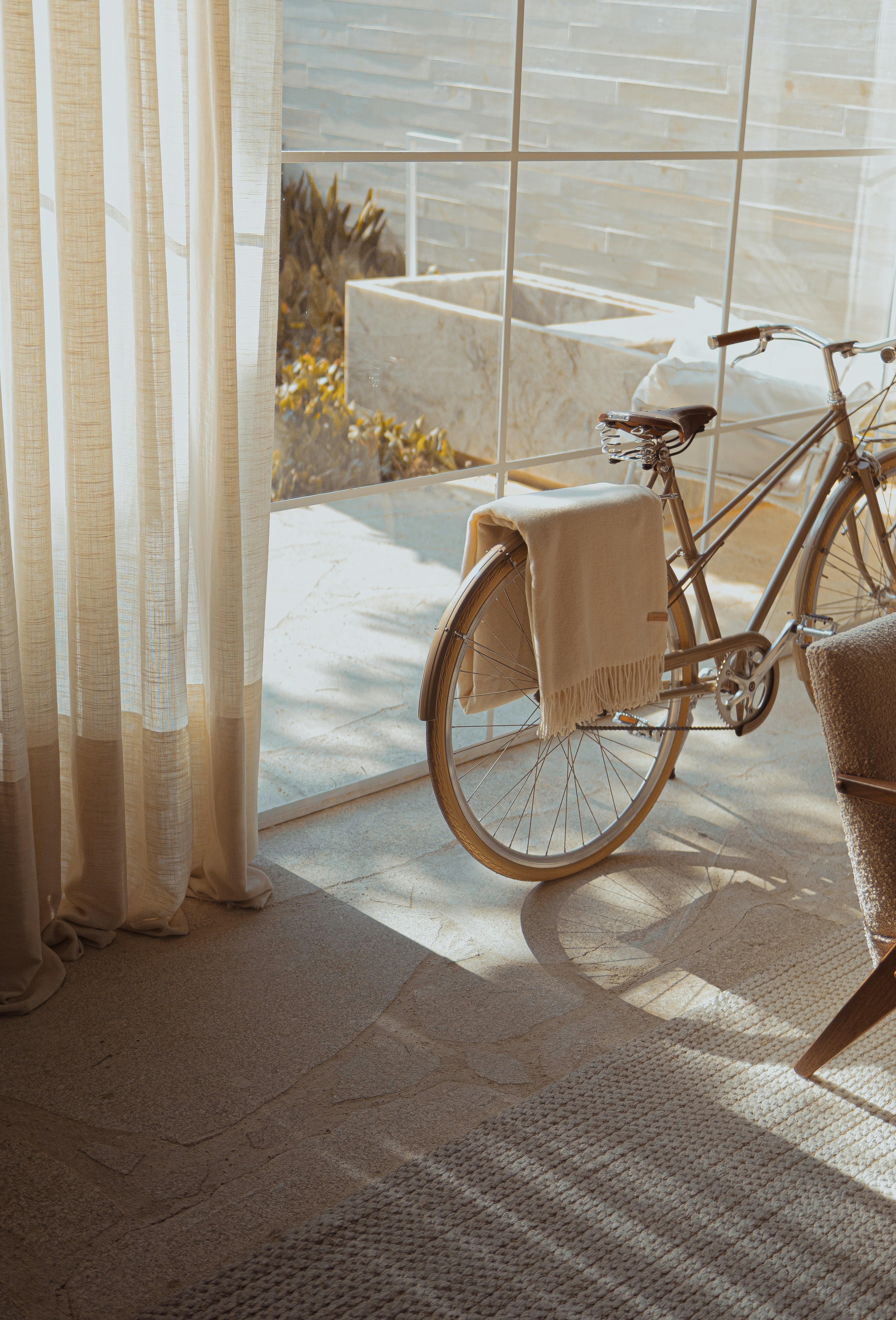 A room with a bicycle and a big window overlooking the outside