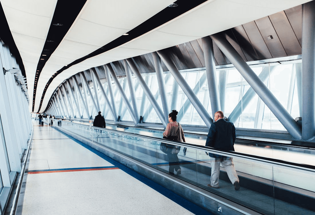 Three Persons Standing on Escalator