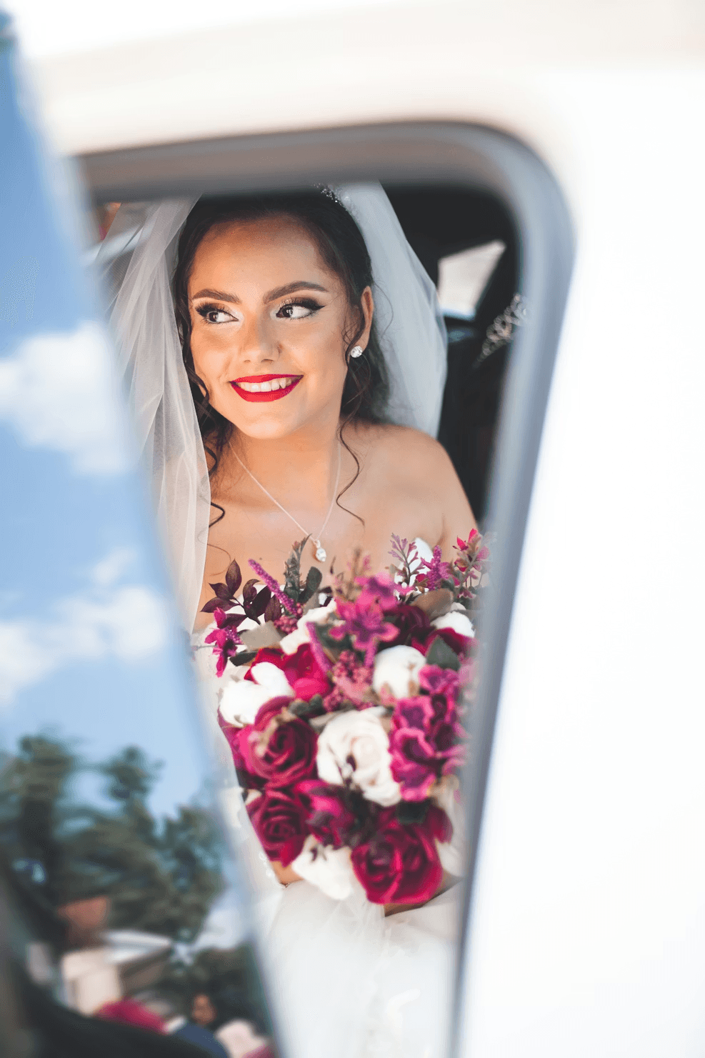 Sposa sorridente in auto dopo il matrimonio, testimonianza di un’esperienza positiva e condivisa grazie all’utilizzo di togevent.