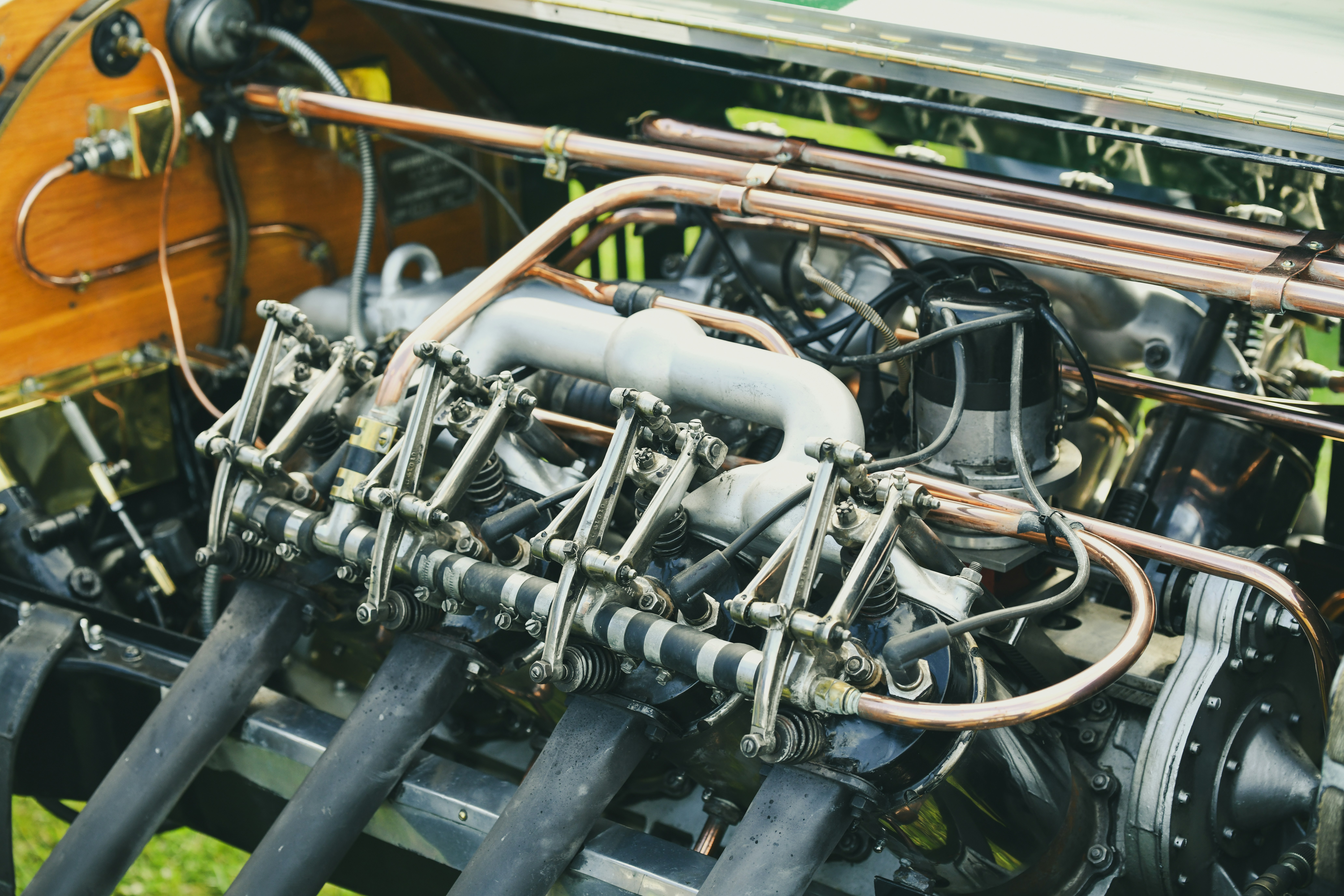 Close-up of a vintage car engine with copper pipes.