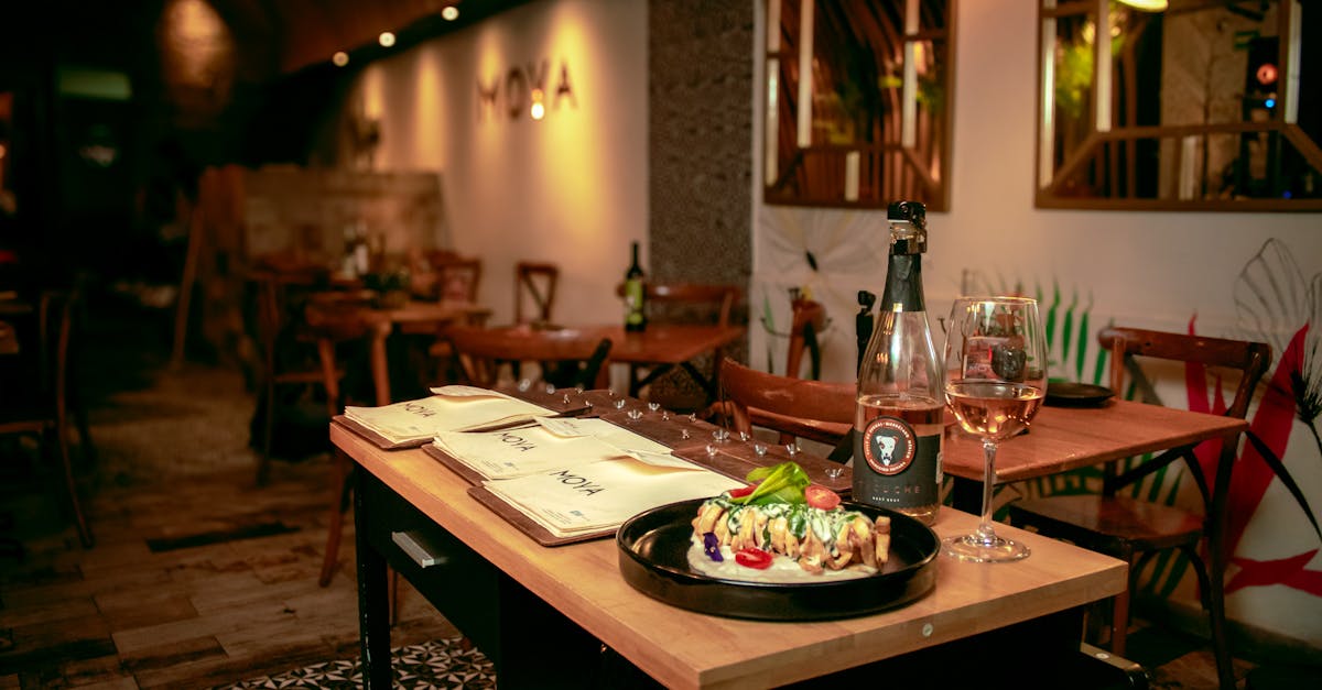 Cozy restaurant table with gourmet dish and wine, creating a warm dining ambiance.