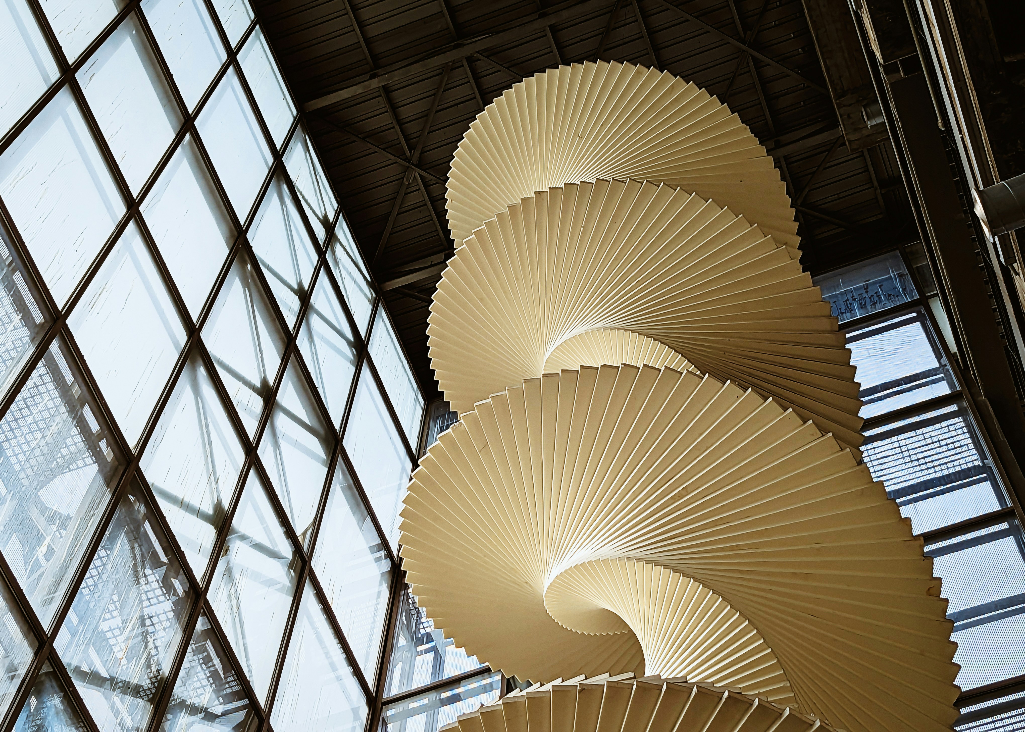 a tall sculpture in front of a window in a building