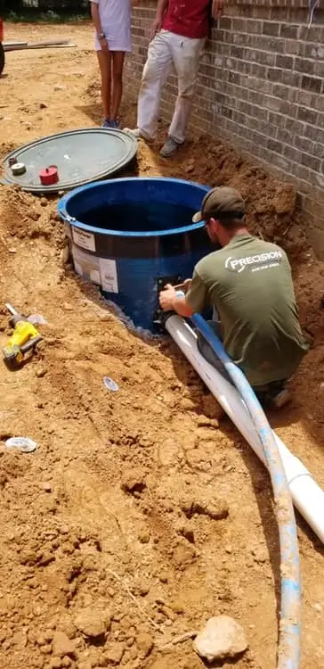 Precision Plumbing & Septic technician in [Location] installing a residential septic tank system