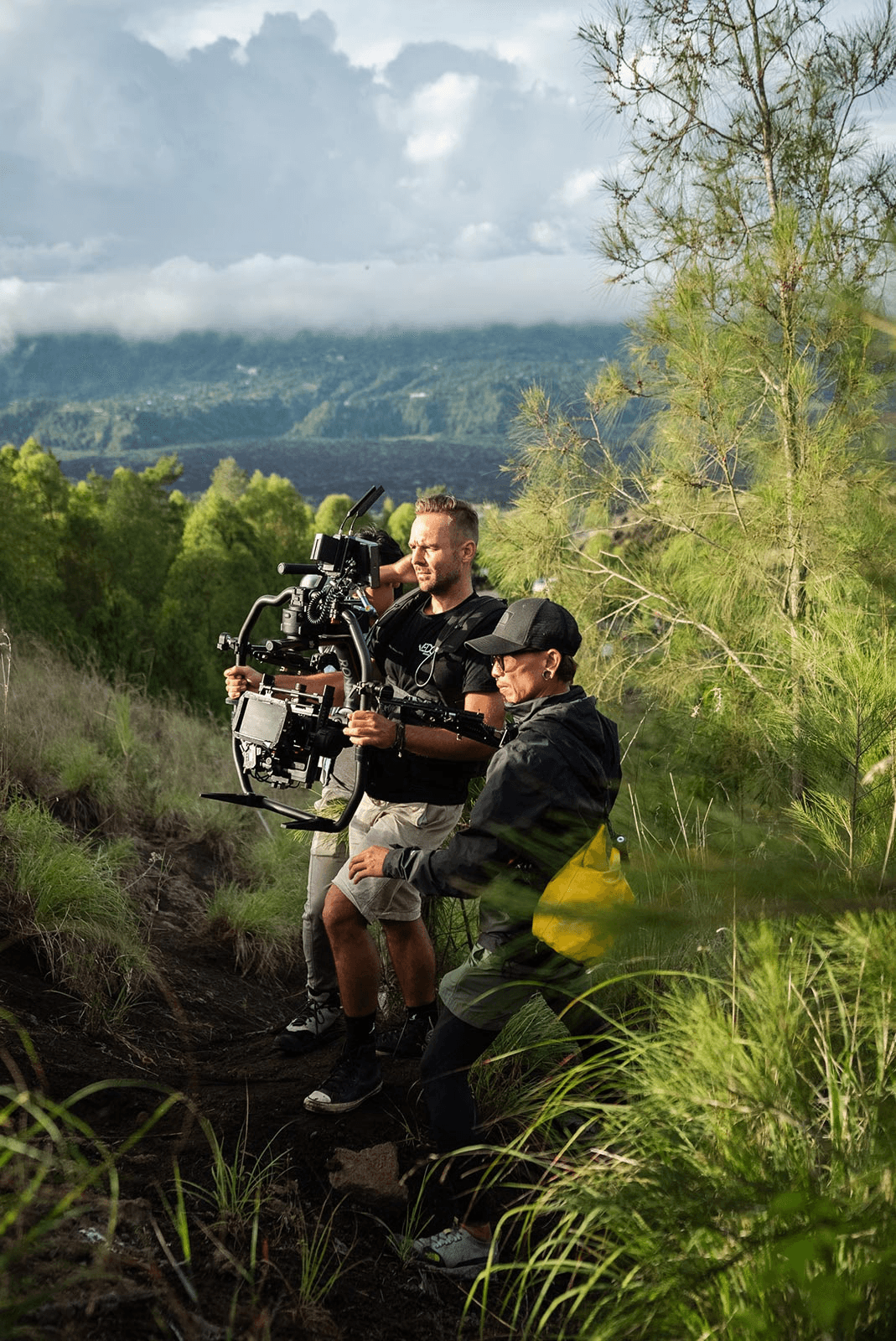 We Do Creative film crew on location during a commercial production shoot in Bali, filming in an open field with the island's tropical hills in the background