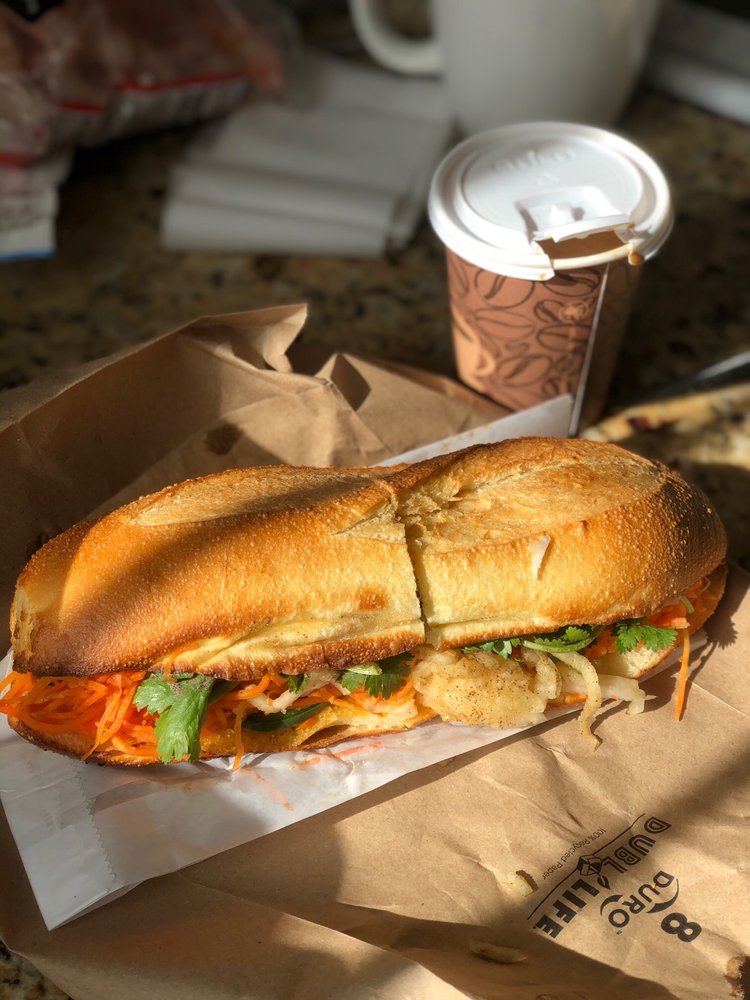 Close-up of Xe May’s Classic bánh mì, featuring Vietnamese cold cuts, pickled vegetables, and creamy pâté on a fresh baguette.