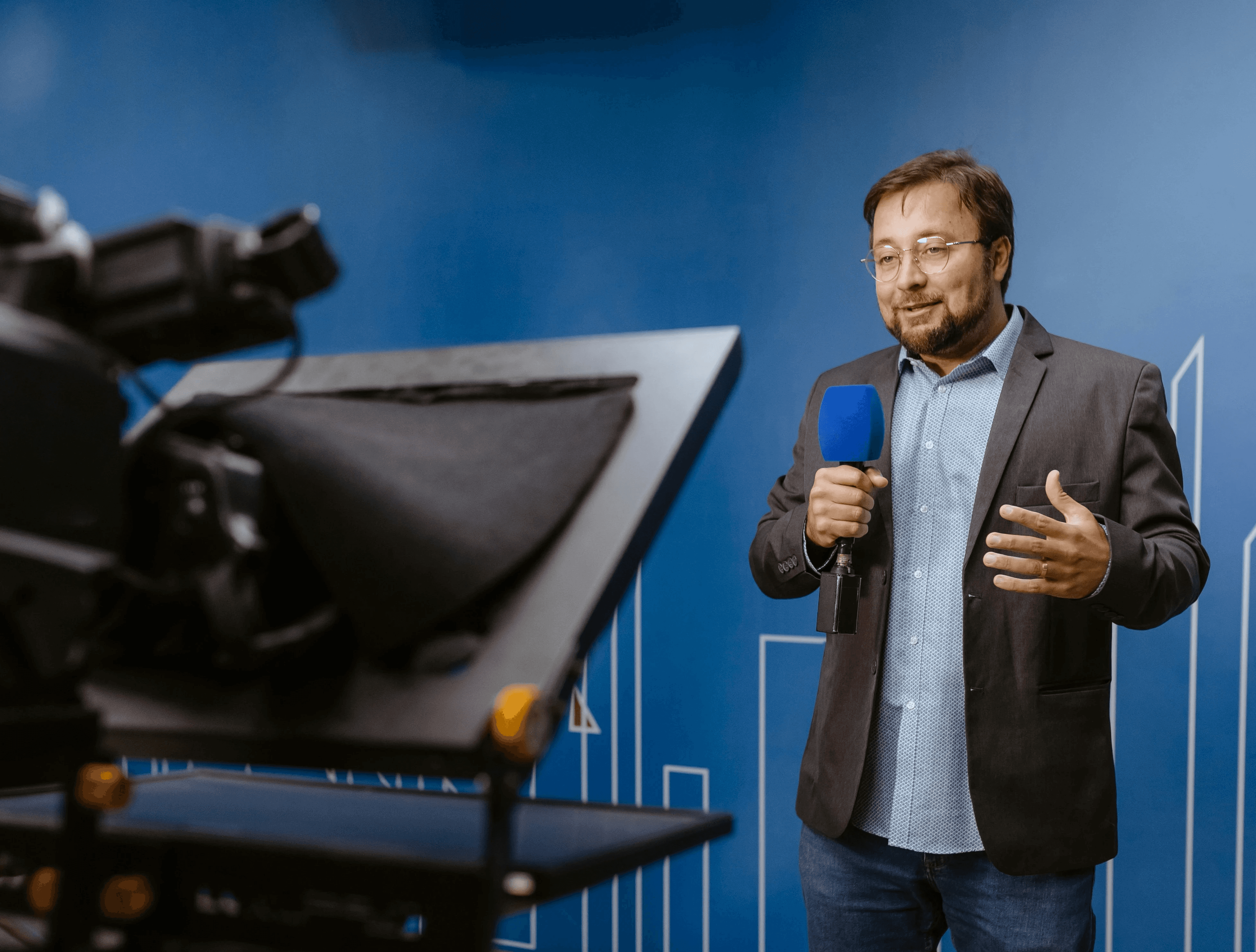 Three professionals in a modern office hallway engaged in a discussion, showcasing a collaborative and professional atmosphere.